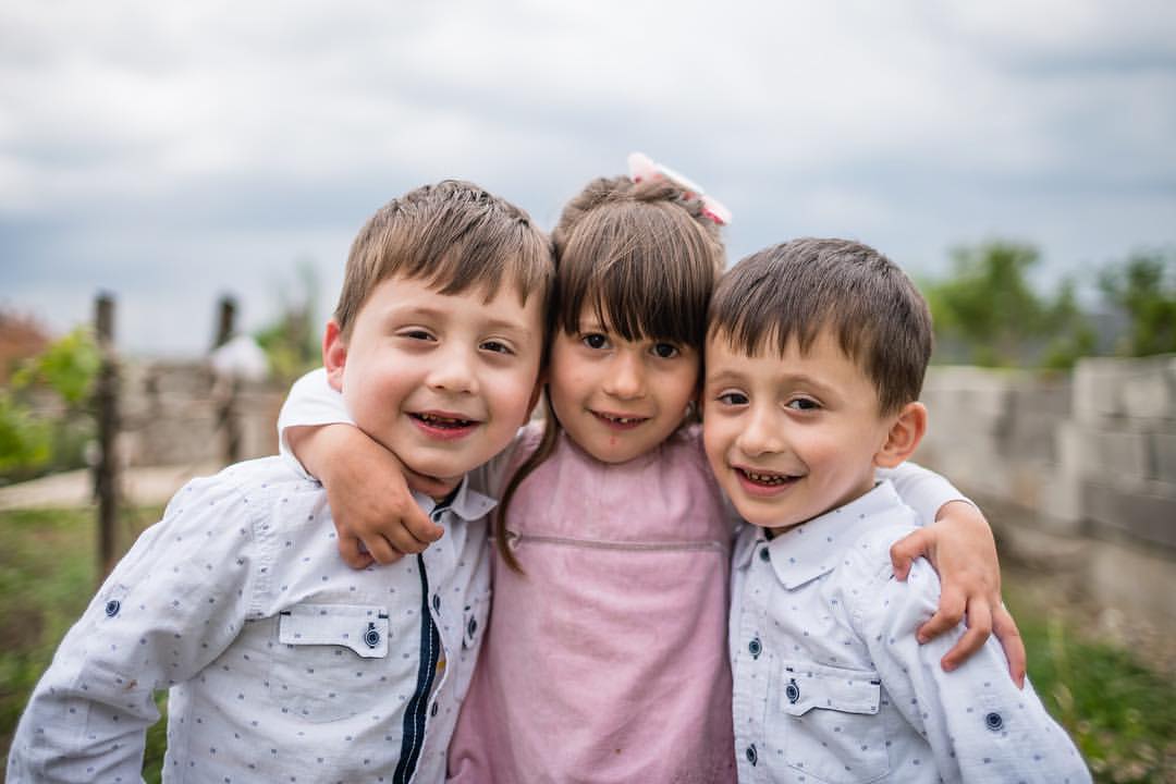 t's gratifying when I get to photograph a success story. These three are triplets born severely under term in Kosovo. They survived due to the efforts of their amazing doctor, and to the availability of a drug to help premature babies breathe. These three were a handful running around hopped up on sugar, didn't speak any language I did, and had everyone who was there telling them something different to do. The whole shoot lasted 45 minutes with 40 of them spent in the ritual of eating pastries, cookies, and tea with the family then 5 minutes left for shooting. On assignment for AbbVie with Americares in Kosovo.