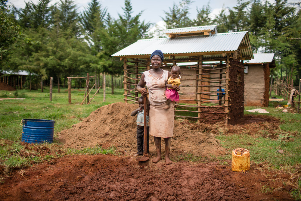 A Kenyan women building her new kitchen by hand, with a design that will reduce smoke.
