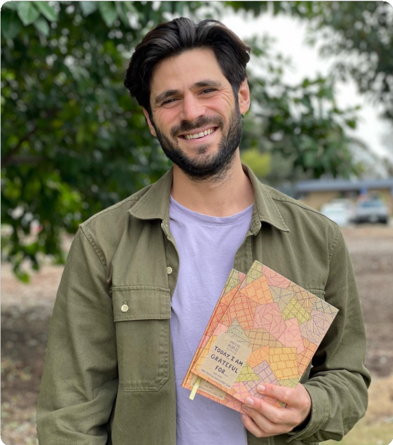 Teddy Droseros, founder of Grateful Peoples, holds a copy of the Gratitude Journal.