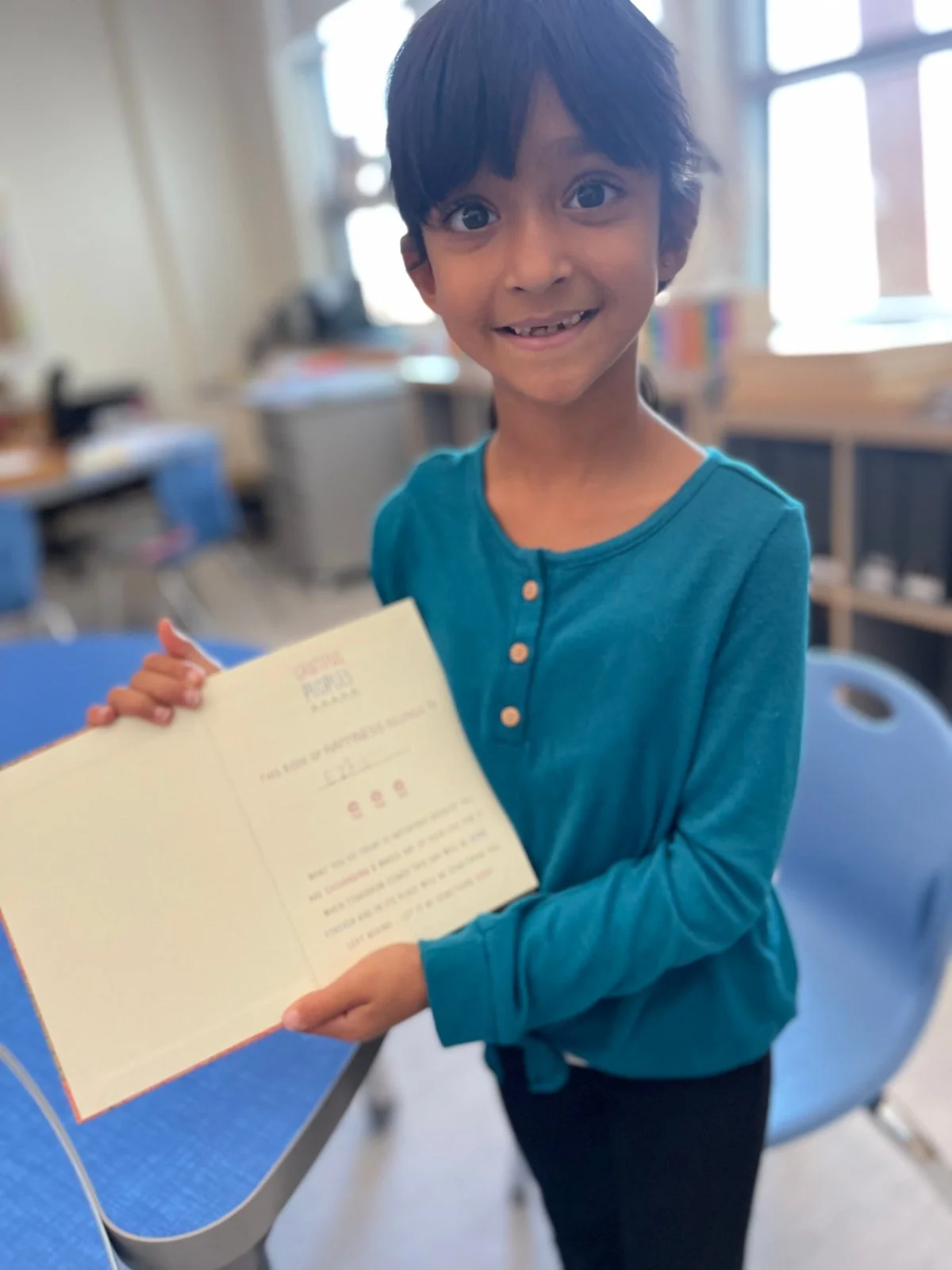 Student displaying the inside cover of her Grateful Peoples Gratitude Journal