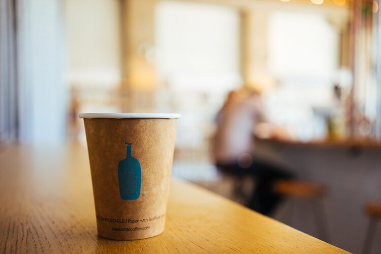 A photo that includes coffee cup, cup, and wood from Blue Bottle