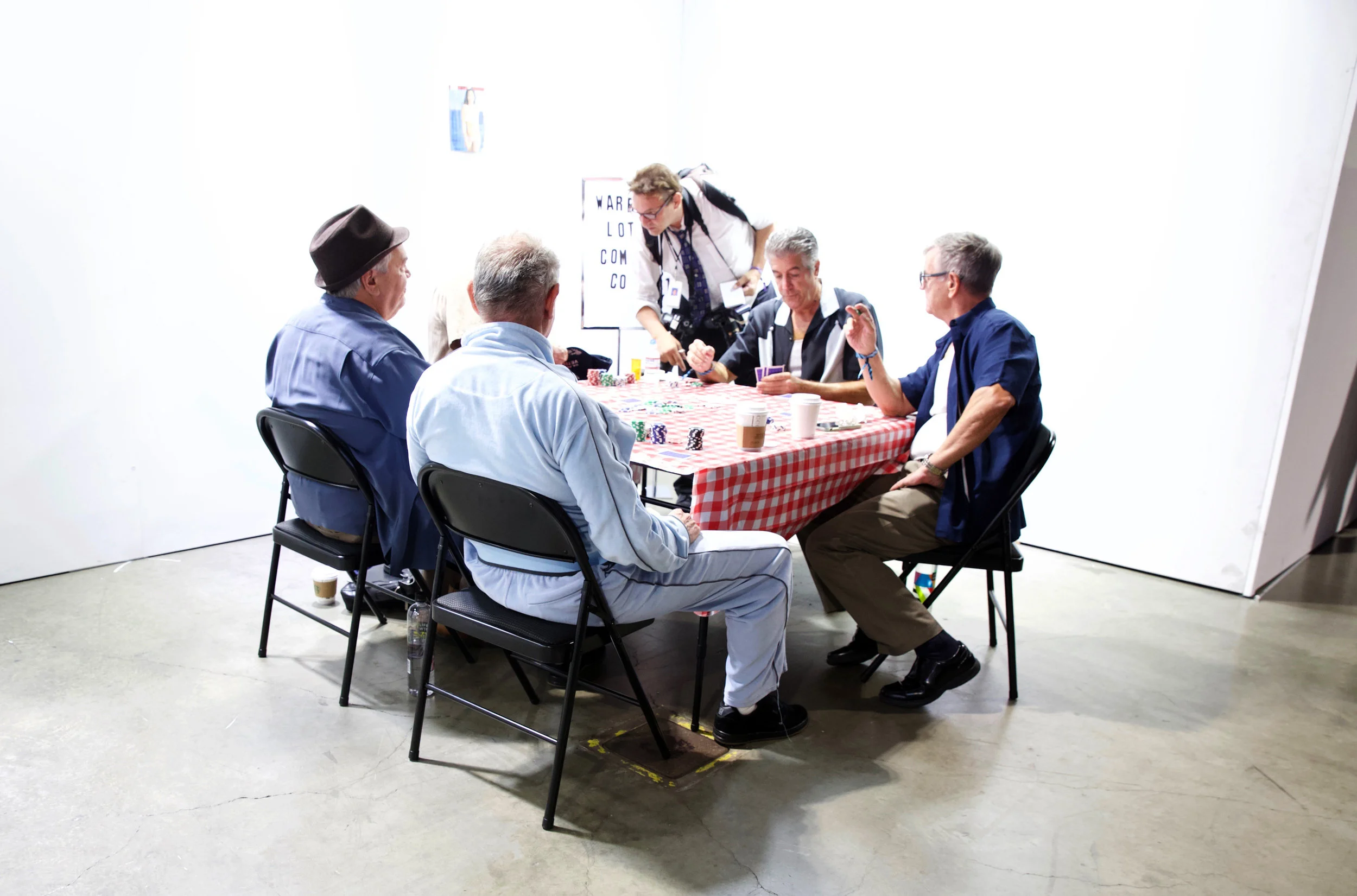  Literal a booth with 4 old guys playing cards 