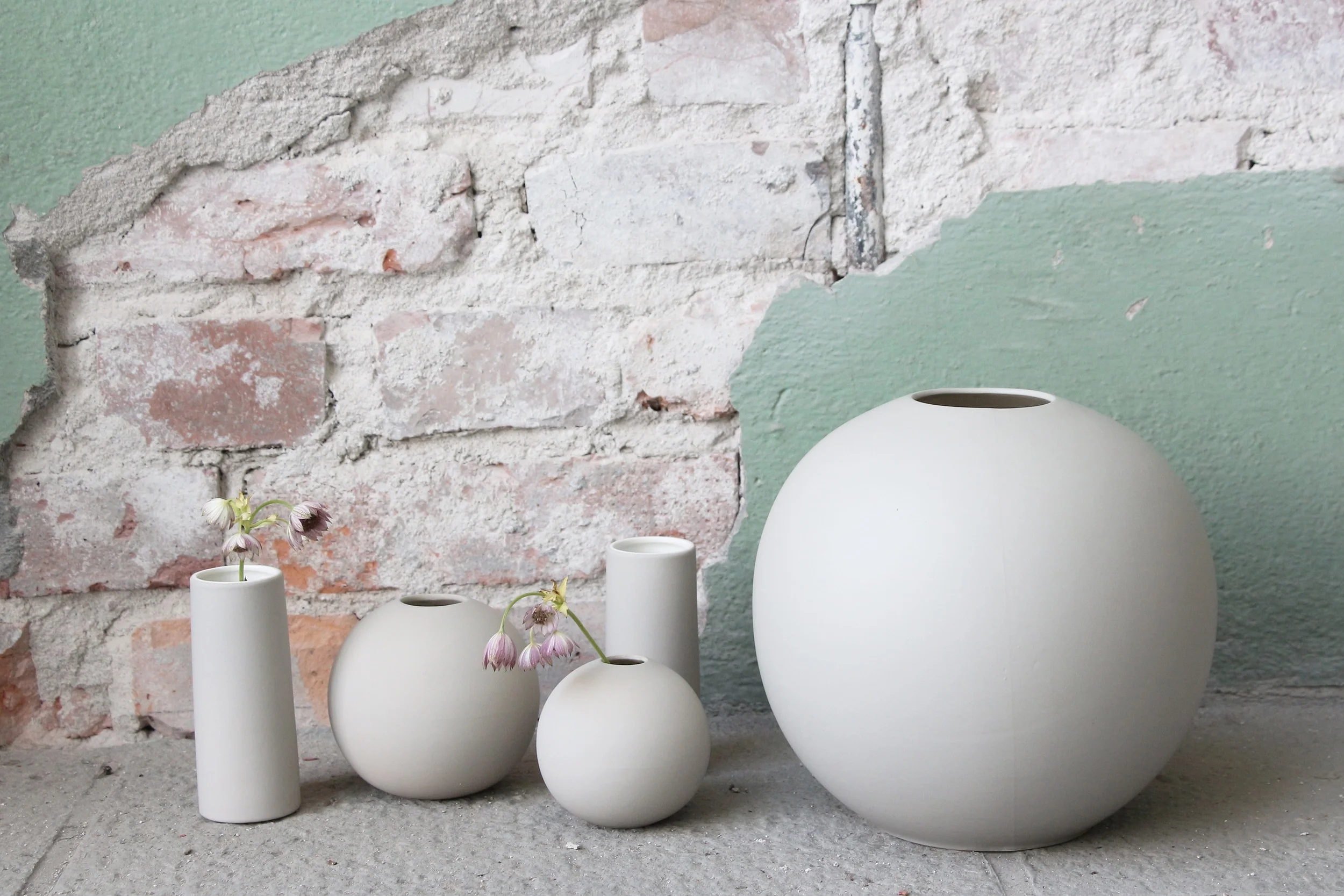 Ball vases and tube vases in sand.