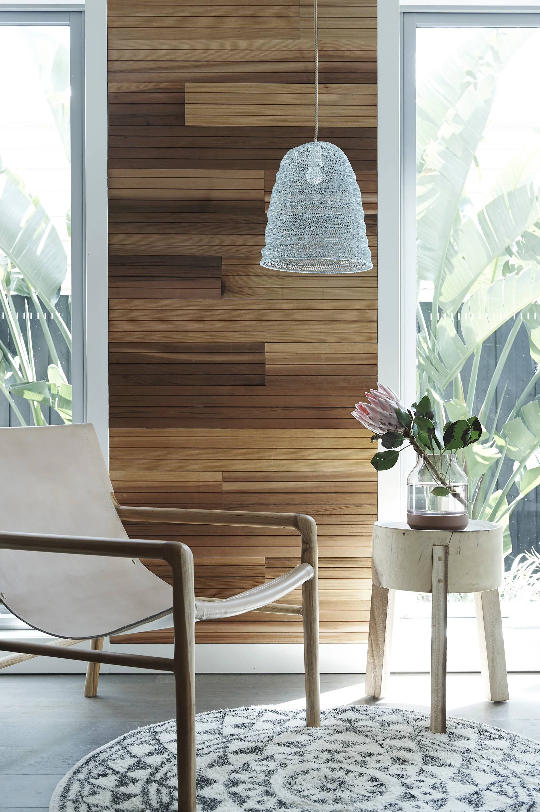 I created a cedar feature wall and stained this in Feast Watson's Scandinavian Oil . Partnered with the Smith leather sling chair by Barnaby Lane and side table and rug by House of Orange . A pendant light by Marmouset Found added a soft ambiance to the room.