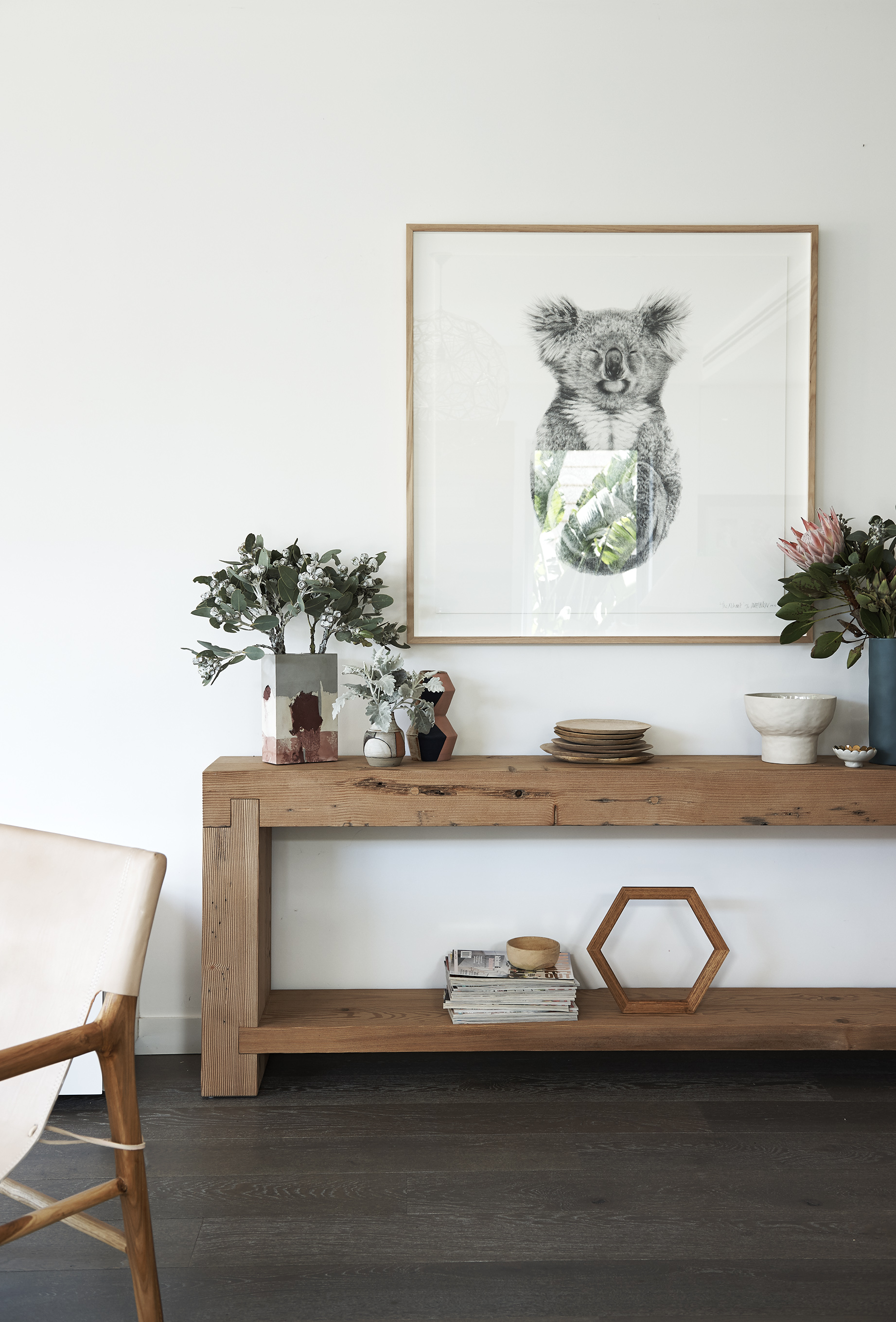 A beautifully chunky Mark Tuckey console table is filled with ceramics by Marmouset Found and Studio Twocan . Above hangs 'The Alchemist' limited edition print by Carla Fletcher . A stack of mango plates from the House of Orange and a custom made timber hexagon were stained with Feast Watson's Traditional timber oil .