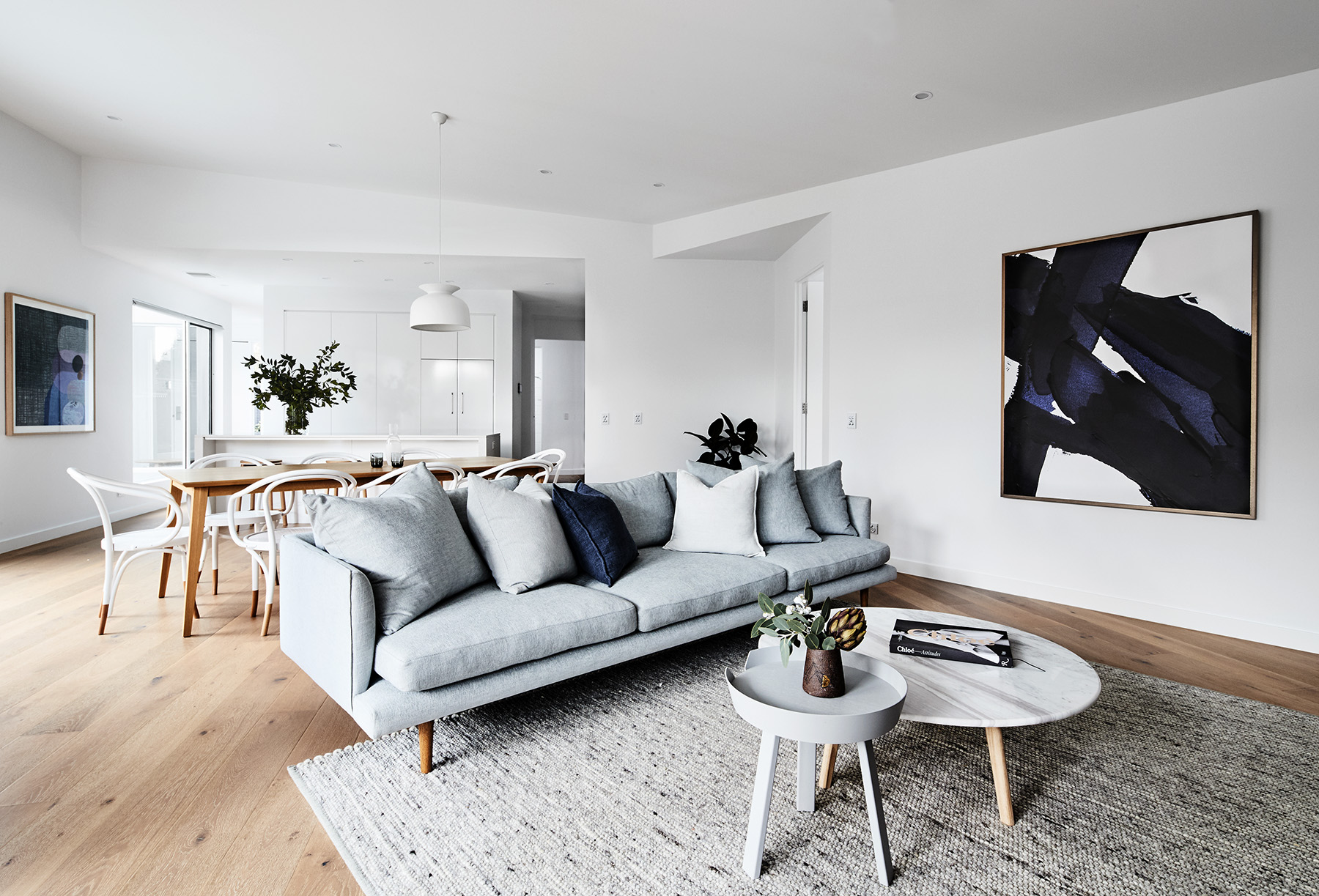 Dining table, Bentwood B9 chairs, Muuto side table, Huset . Artwork "Indigo #1 Kerry Armstrong . Marble coffee table, Harpers Project . Rug, Halcon Lake . Gubi pendant light, Surrounding .