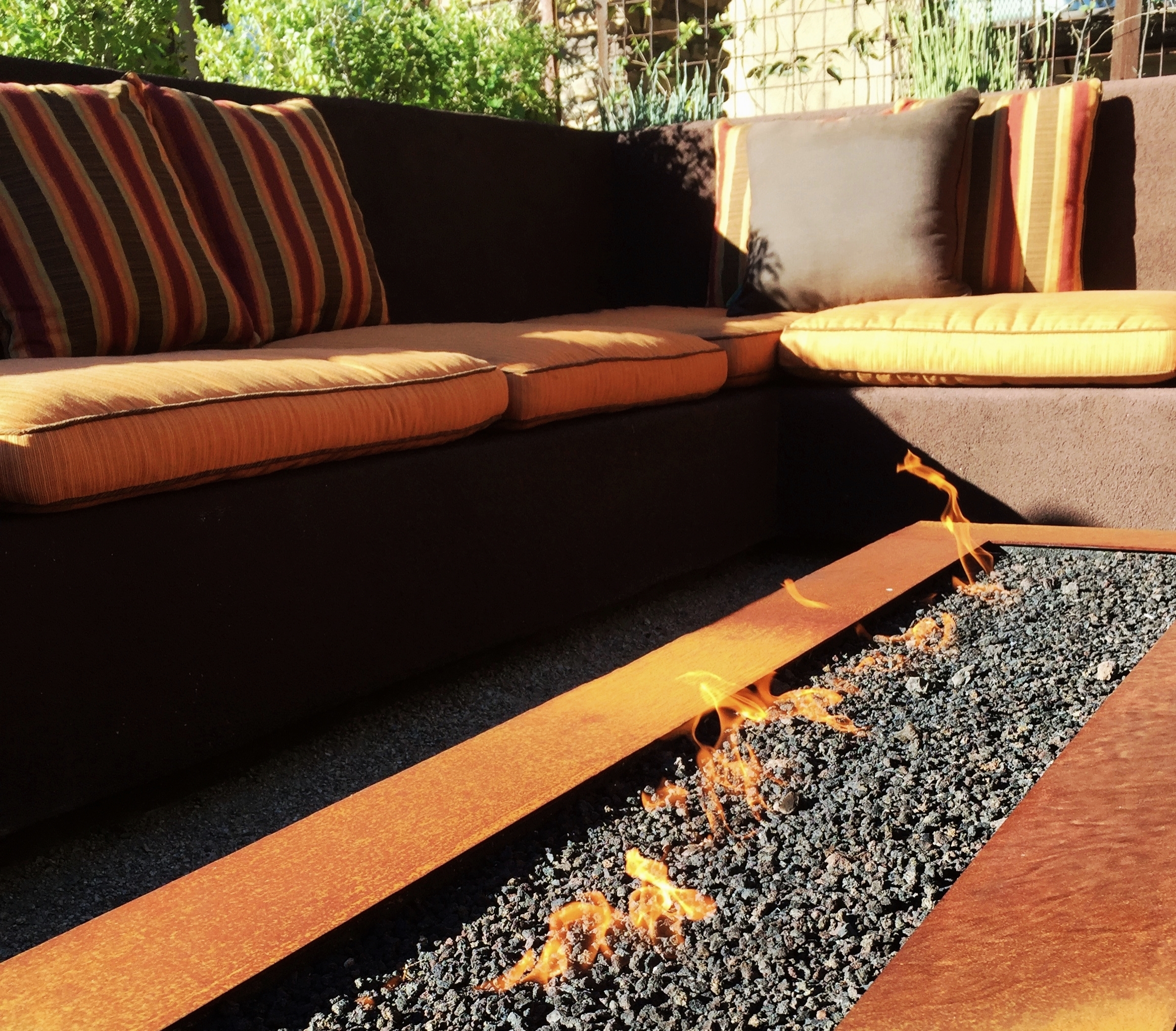 Metal fire feature surrounded by built-in banco seating.