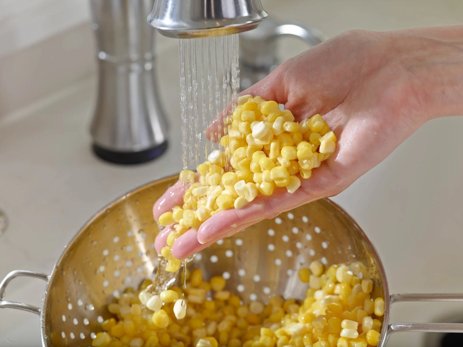 Corn being Washed in a Kitchen Sink