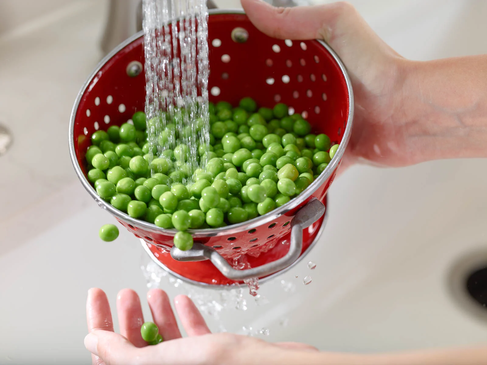 Peas being Rinsed in a Kitchen Sink