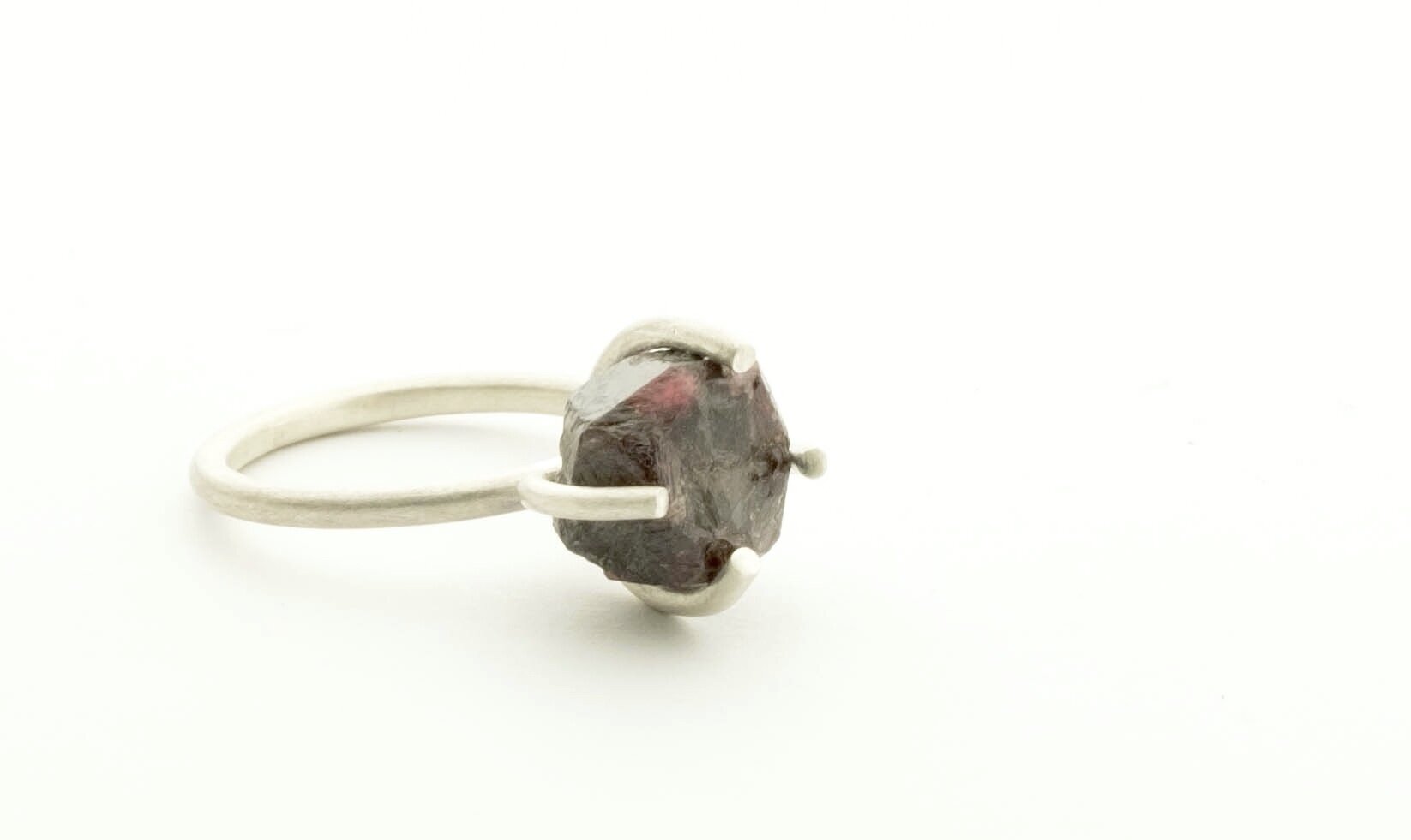 Claw ring in silver with raw ruby garnet