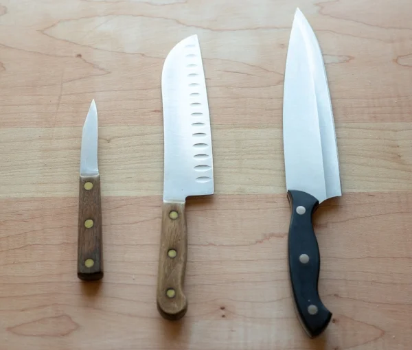 From left to right: Pairing knife and two chefs knives. The middle knife has a Granton Edge which creates air between the blade and what you're cutting, making it easier to slice.
