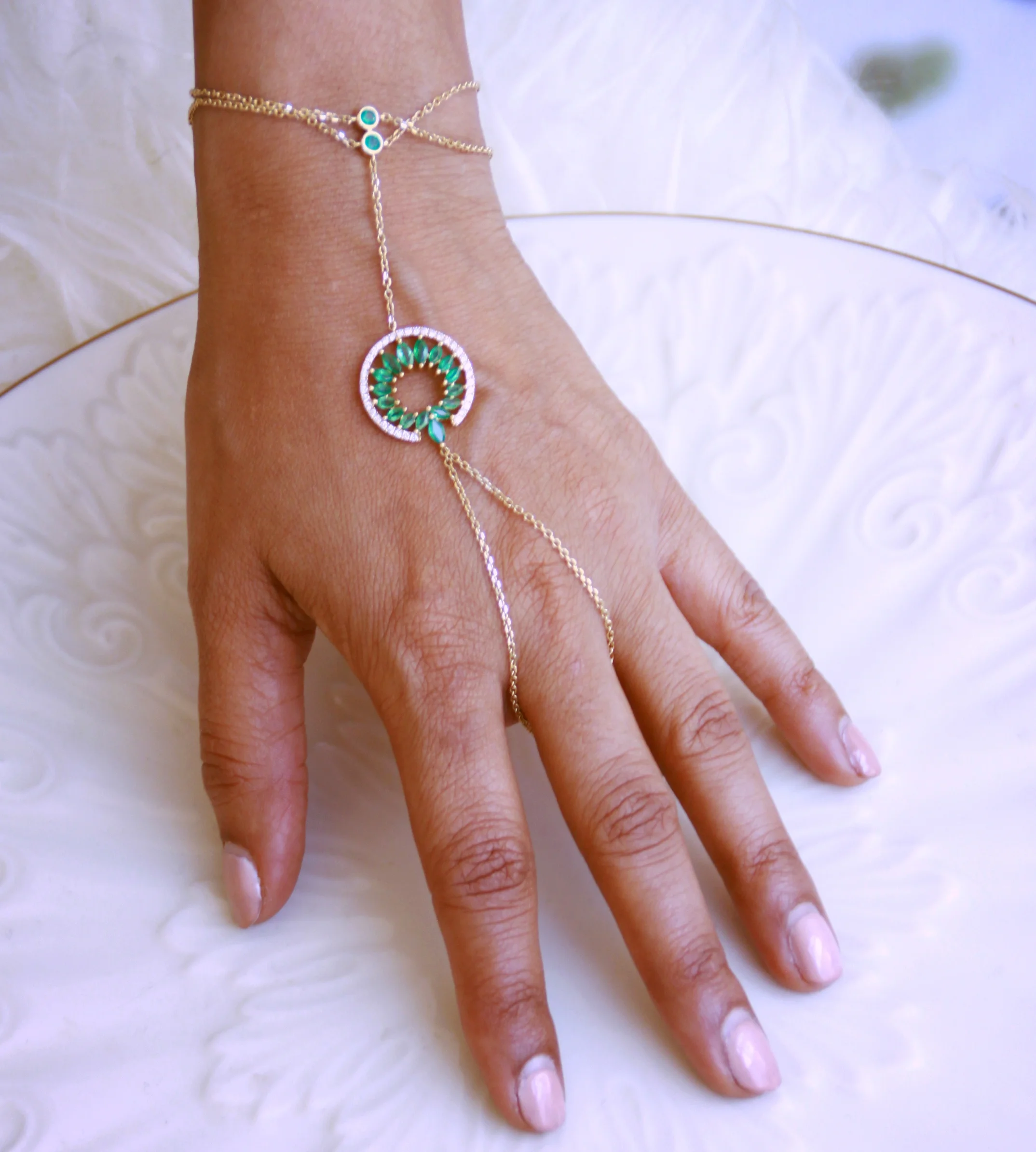 Inspired by the Indian bridal jewelry, called Hath (Hand) jewelry, this hand chain embodies the beauty of a women by the movement and the marquis emeralds floating freely around the hand.