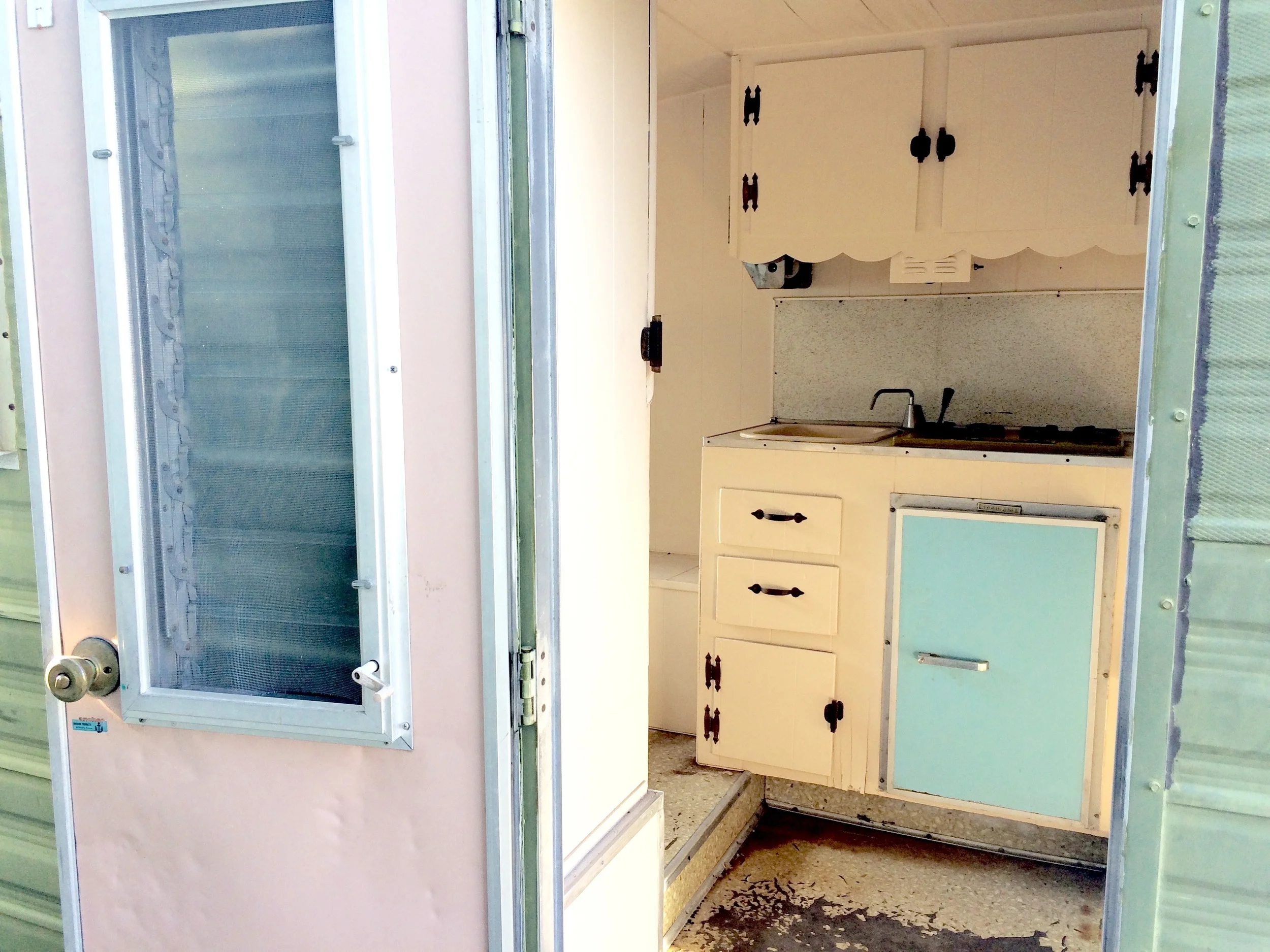 View looking into the trailer at the kitchenette. Dining area is to the right and lounge/bed is to the left.