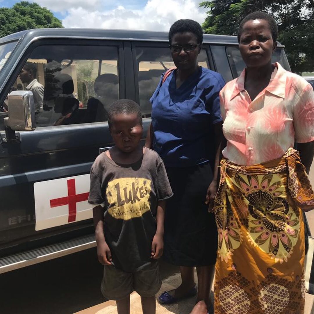  David, his mother, and a family member stand outside an ambulance at Nkhoma Mission Hospital where David received the first of two surgeries to debulk his facial tumor. 