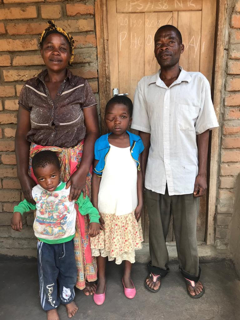  Coleta and her immediate family stand in front of their home. 