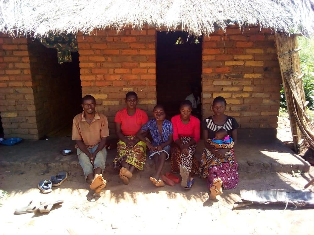 Mphatso's family in front of their home