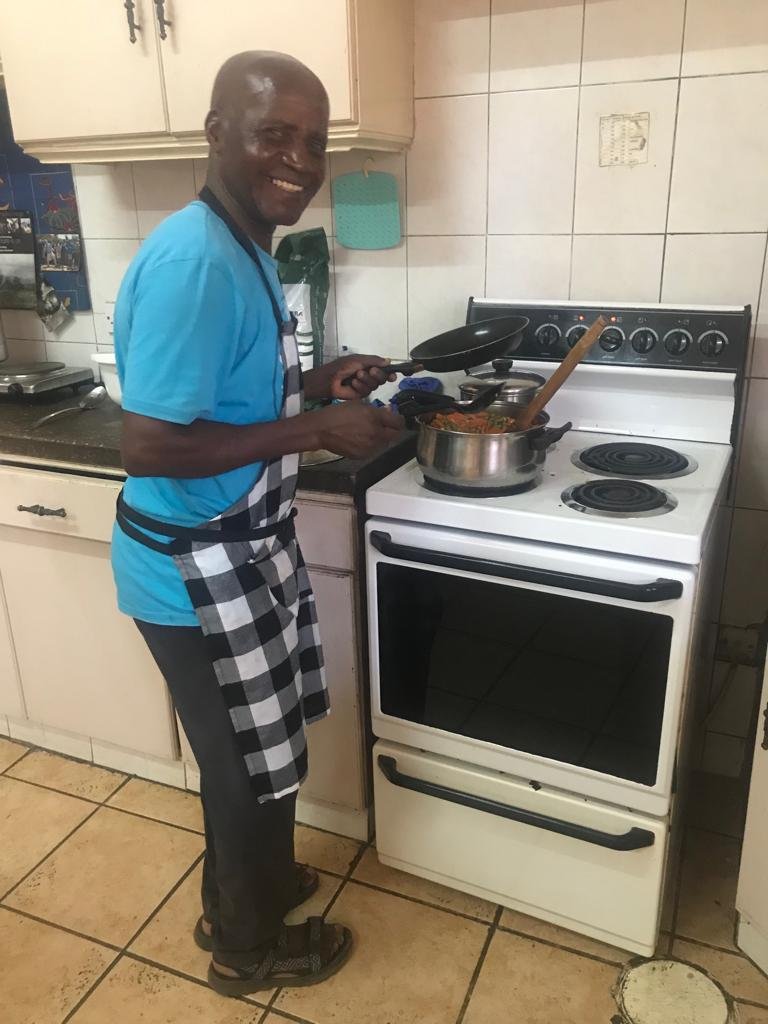  John smiles while cooking at the AHA house. 