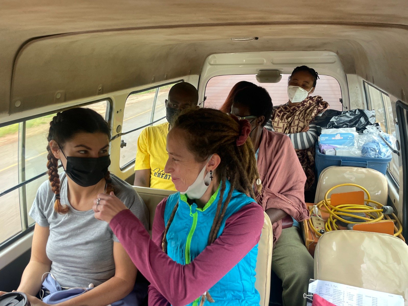 Christina (center right) sits on a bus with the AHA team on the way to a surgical camp at Kab.