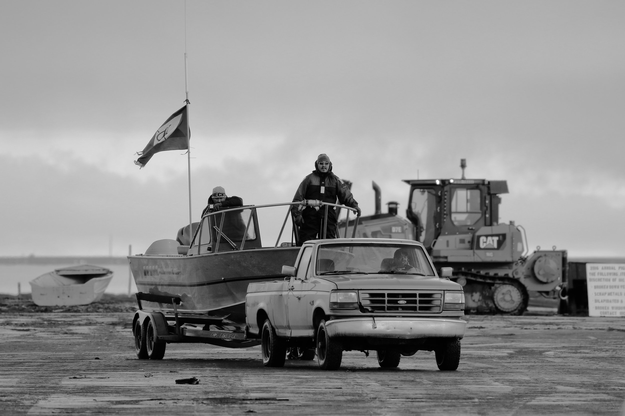 The Captain of the successful whaling crew returns from the ocean with their flag proudly displayed. 