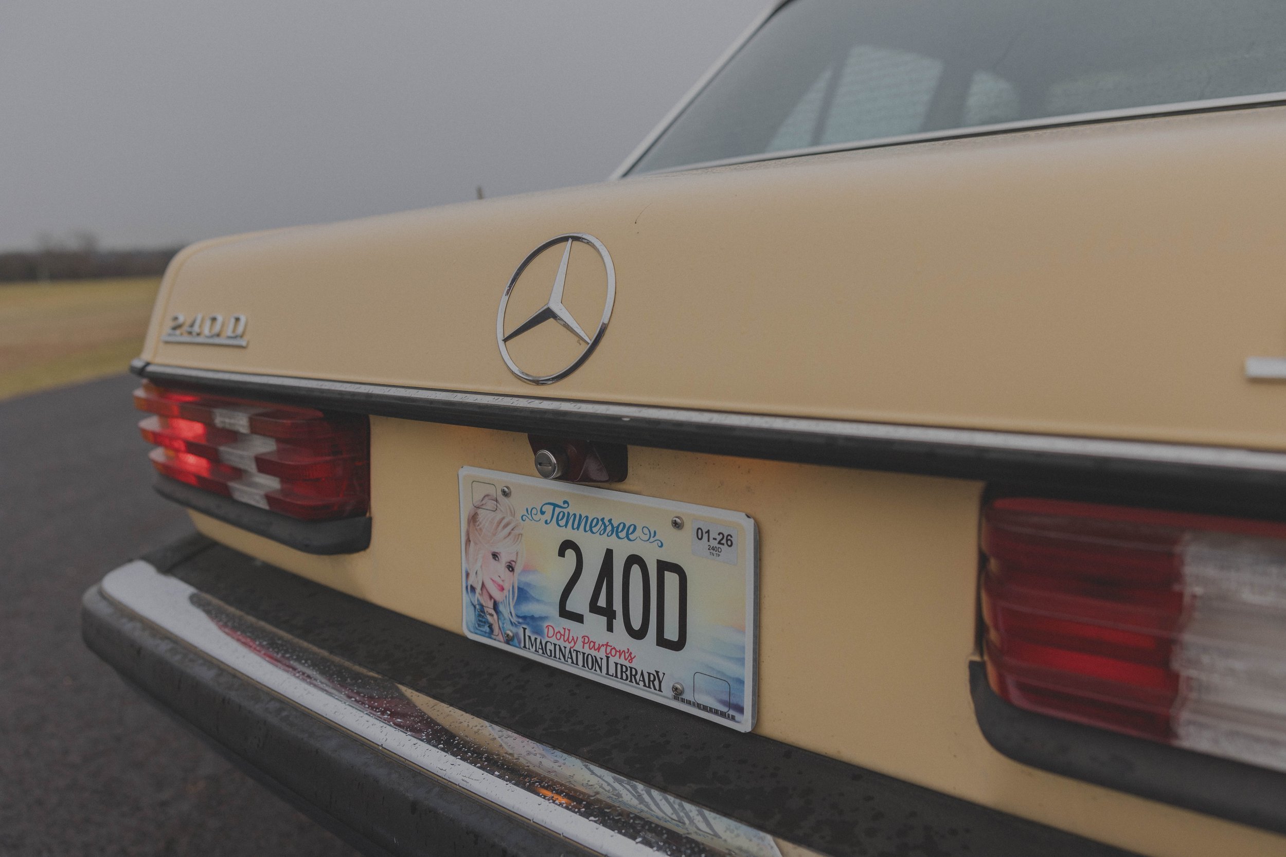 Rear view of a beige Mercedes-Benz 240D with a Tennessee license plate featuring a design for Dolly Parton's Imagination Library.