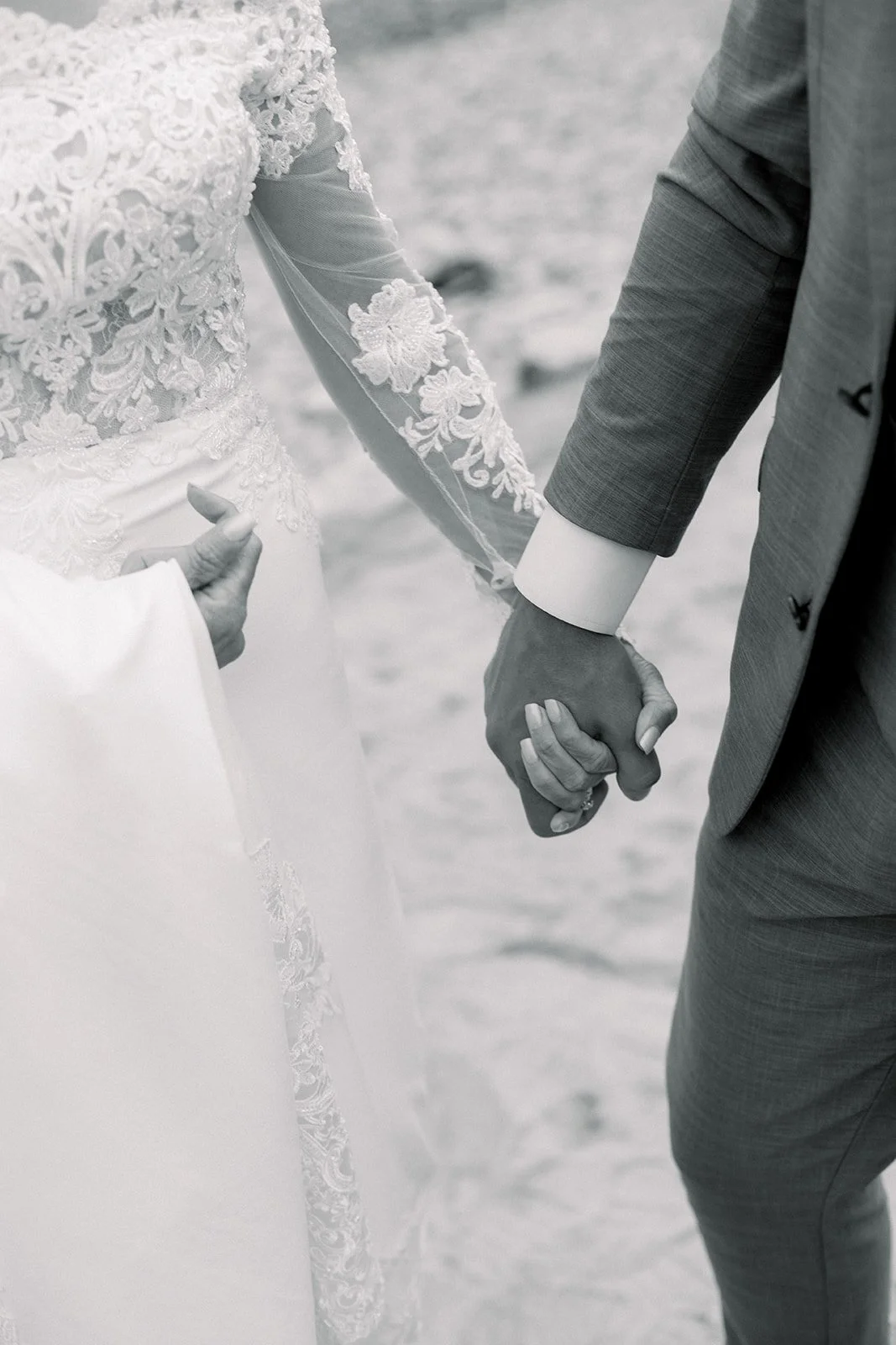 Black and white photo of bride and groom holding hands at Descanso Beach Club wedding