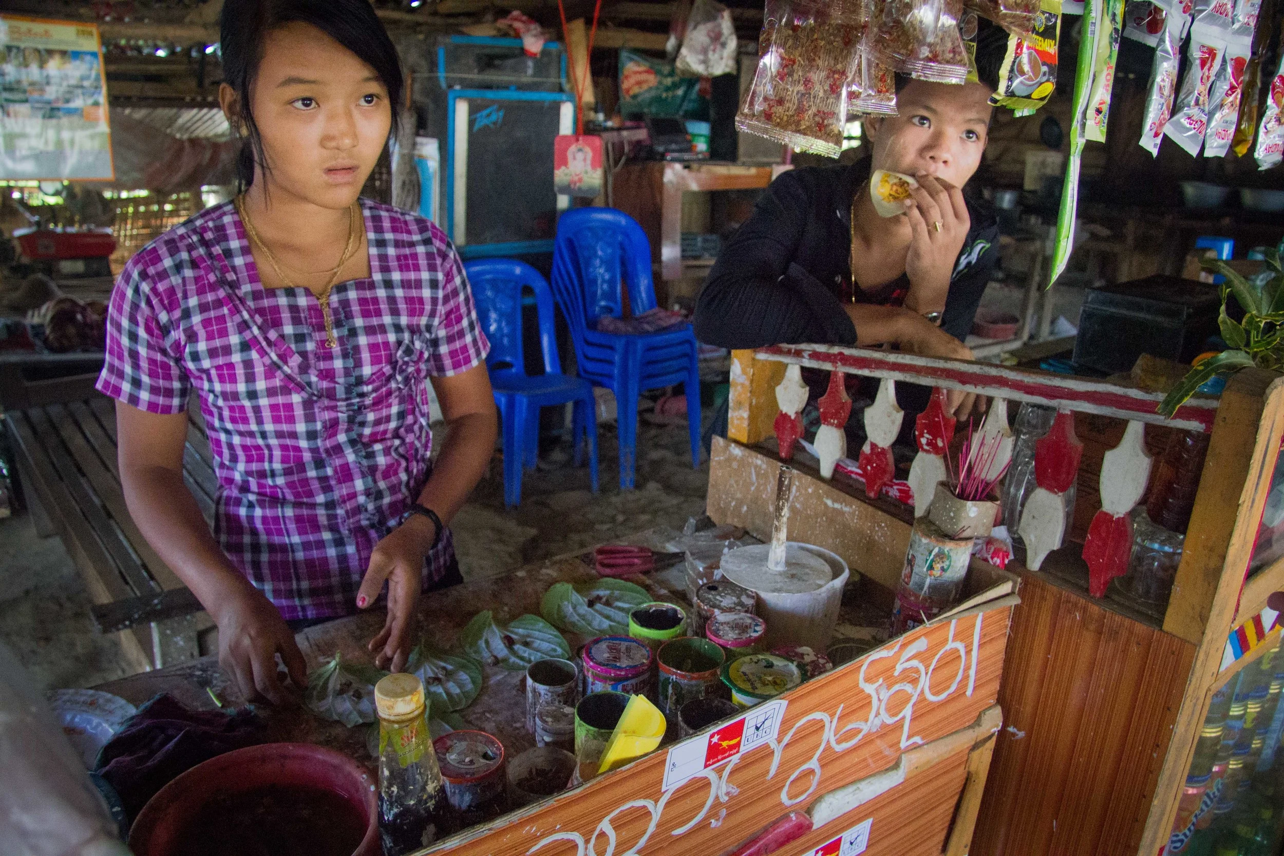 A girl concocts some betel leaves with tobacco and flavouring for a customer 