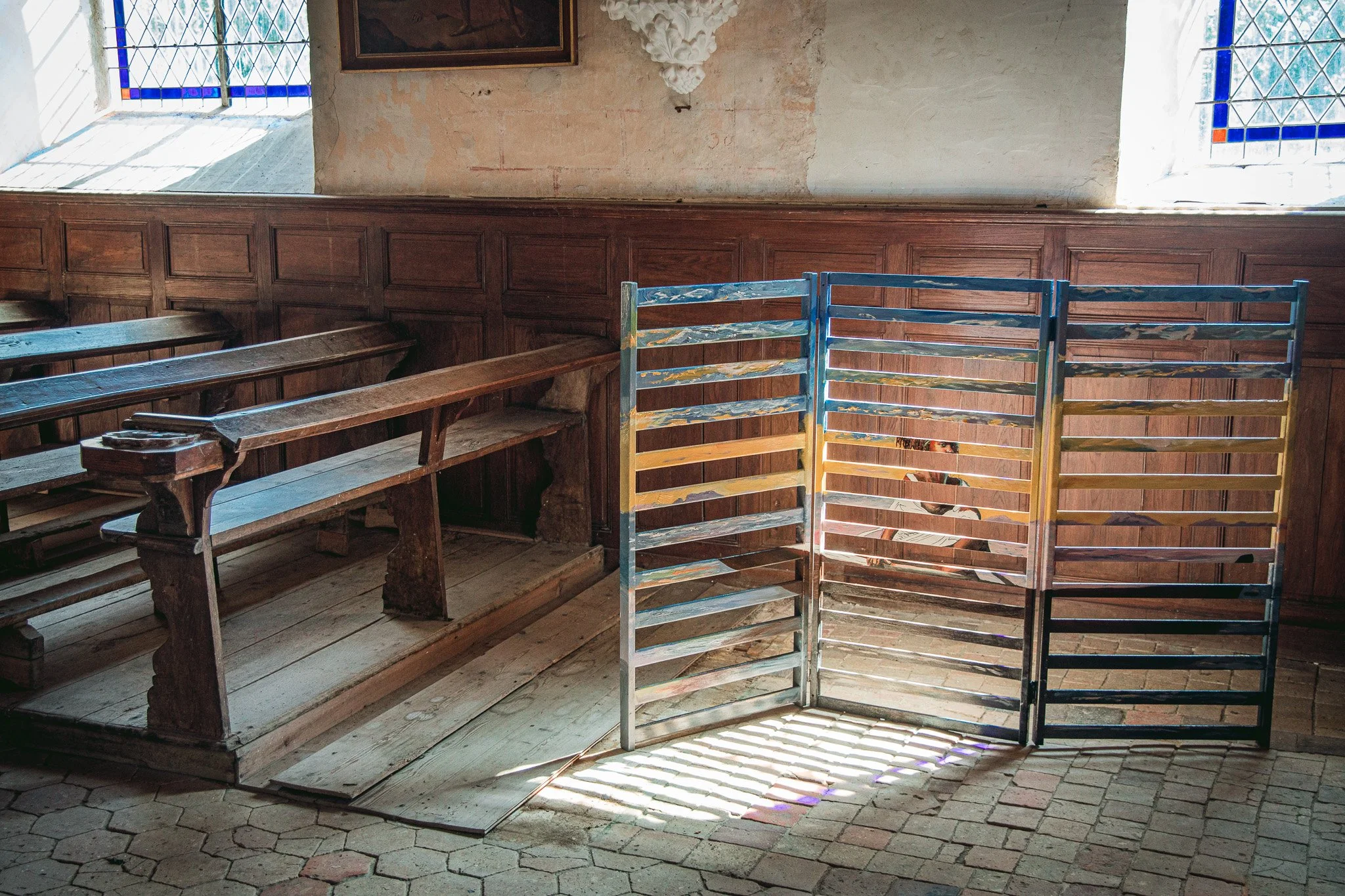 Miroir Normand, Daniel Nicolaevsky, église Saint-Vincent de Martagny, 2026 : douves peintes posées entre les bancs de l'église.