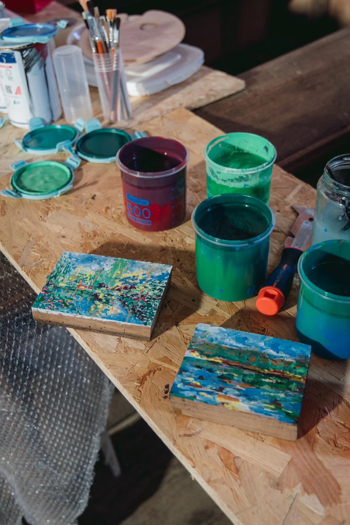 Miroir Normand, Daniel Nicolaevsky, église Saint-Vincent de Martagny, 2026 : pots de peinture verte et bleue et petits tableaux.