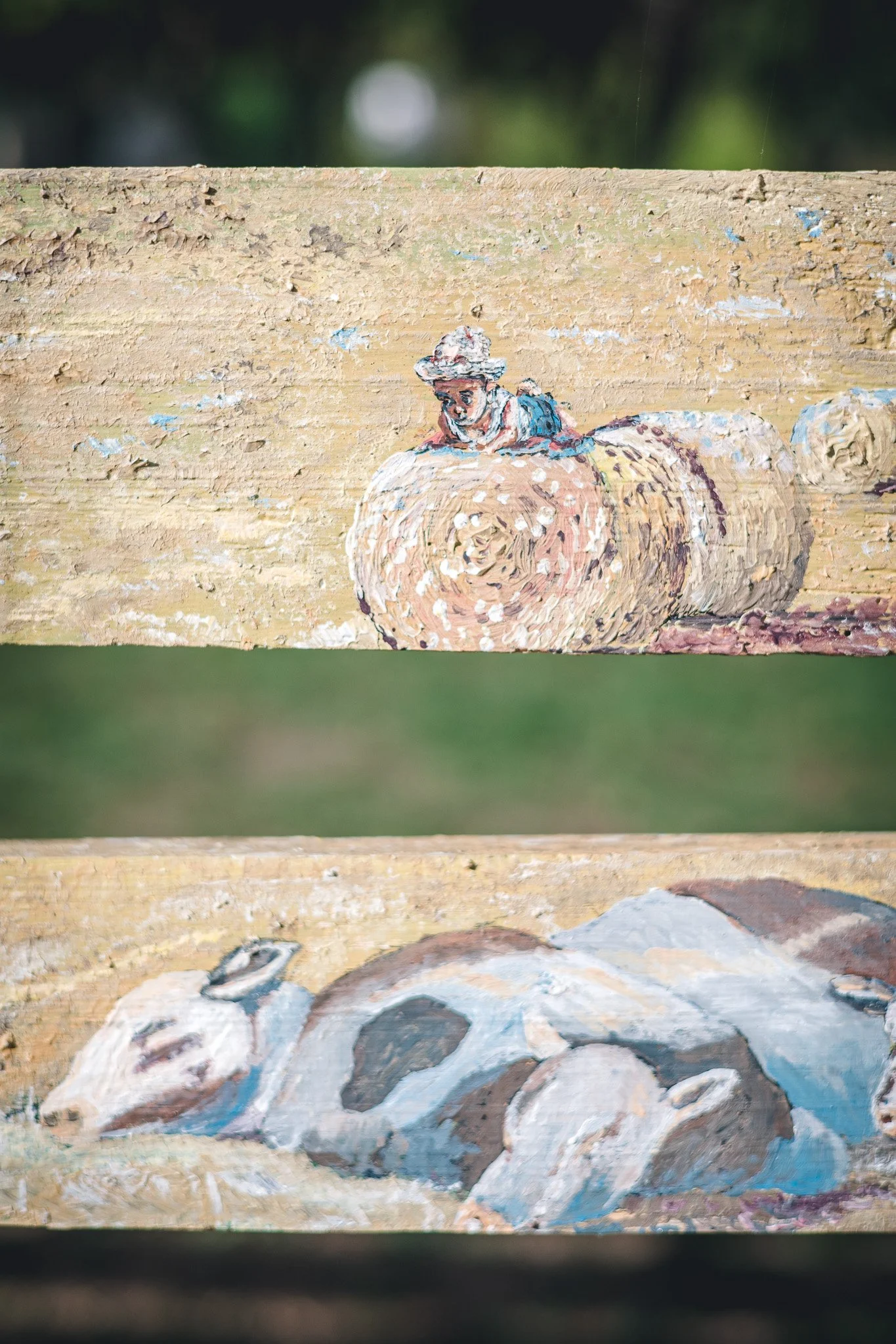 Peinture sur bois représentant un garçon avec un chapeau assis sur un rouleau de tissu ou de papier et d'autres objets en bas.
