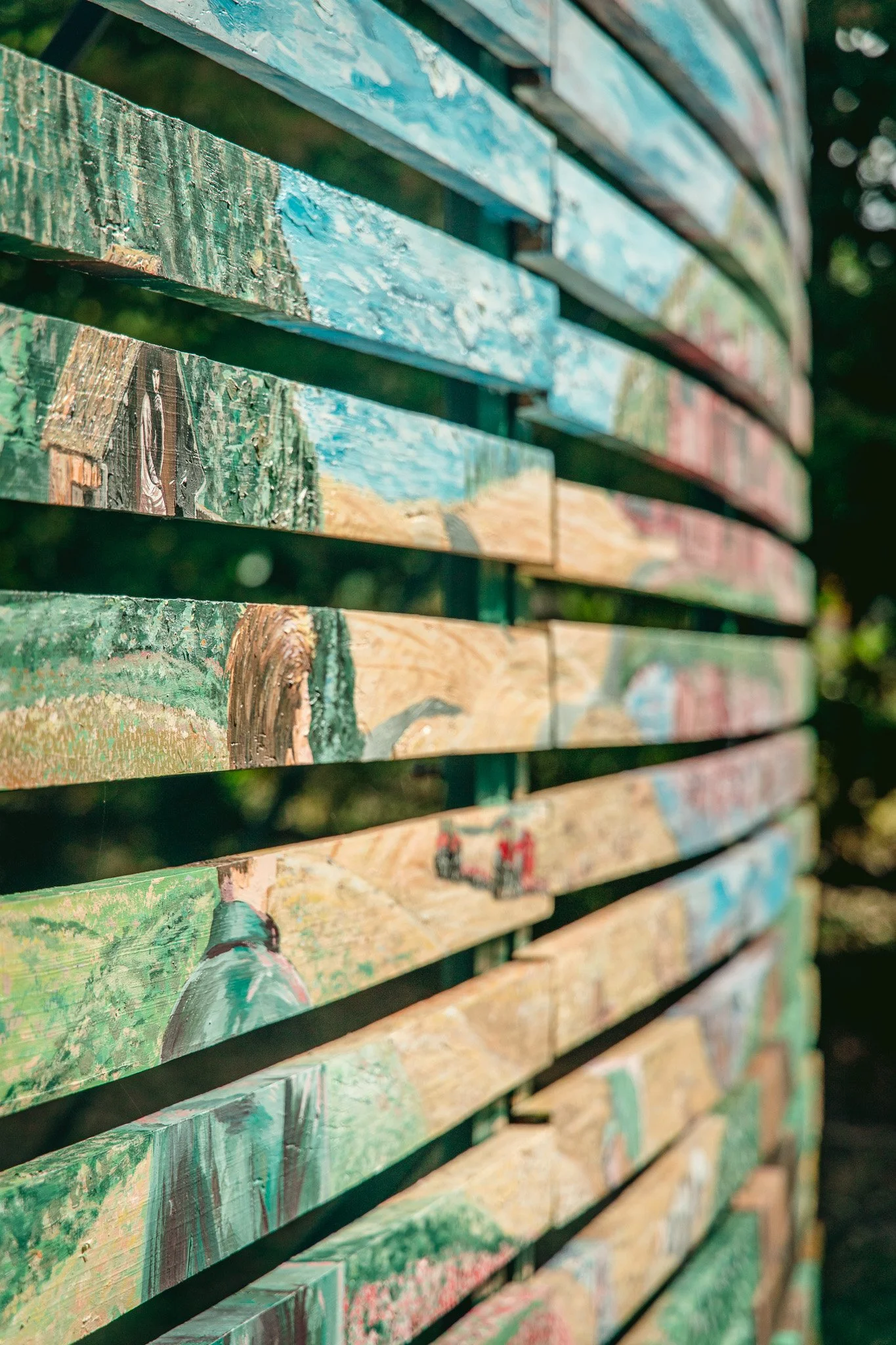 Un mur de planches en bois peintes avec des couleurs variées, vue en gros plan.