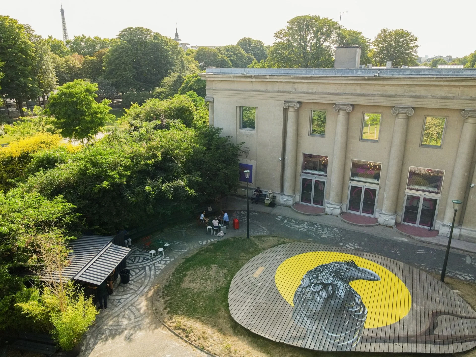 Anu Preto, peinture de Daniel Nicolaevsky devant le Théâtre de la Concorde, Paris, 2025 : l'anu noir sur son soleil jaune, peint sur l'estrade ronde du jardin, vue aérienne.