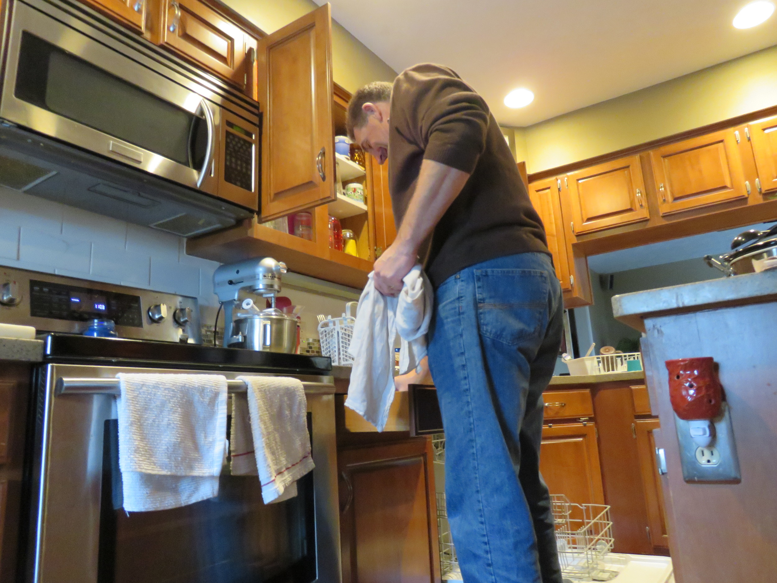 My father emptying the dishwasher.