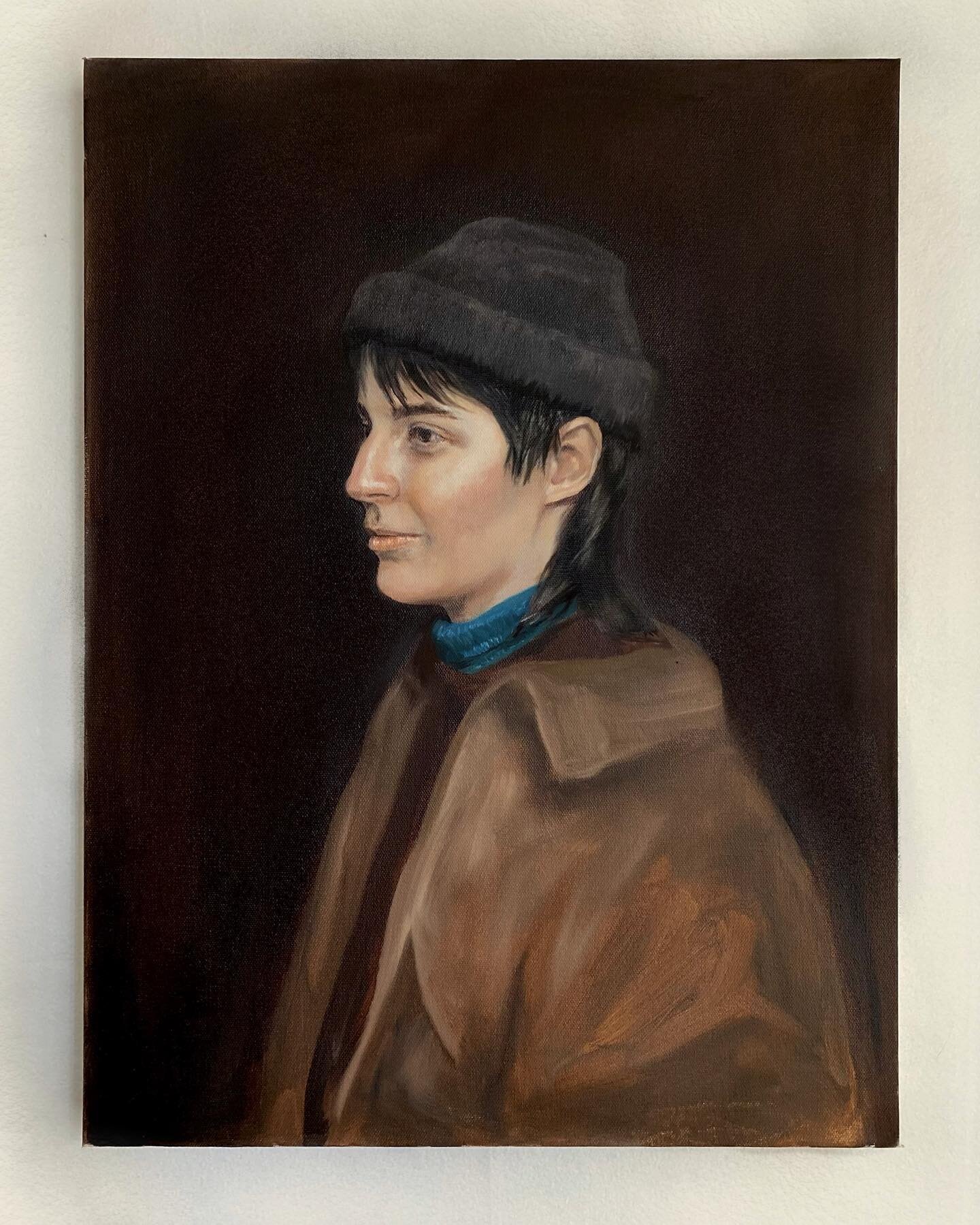 Tereza, 2022
Oil on canvas 

Image description:
Image one: An oil painting of Tereza, a white non-binary 27 year old. They are sitting at a 3/4 angle. They look to the left of the image. They are wearing a black beanie and have on a turquoise turtle 