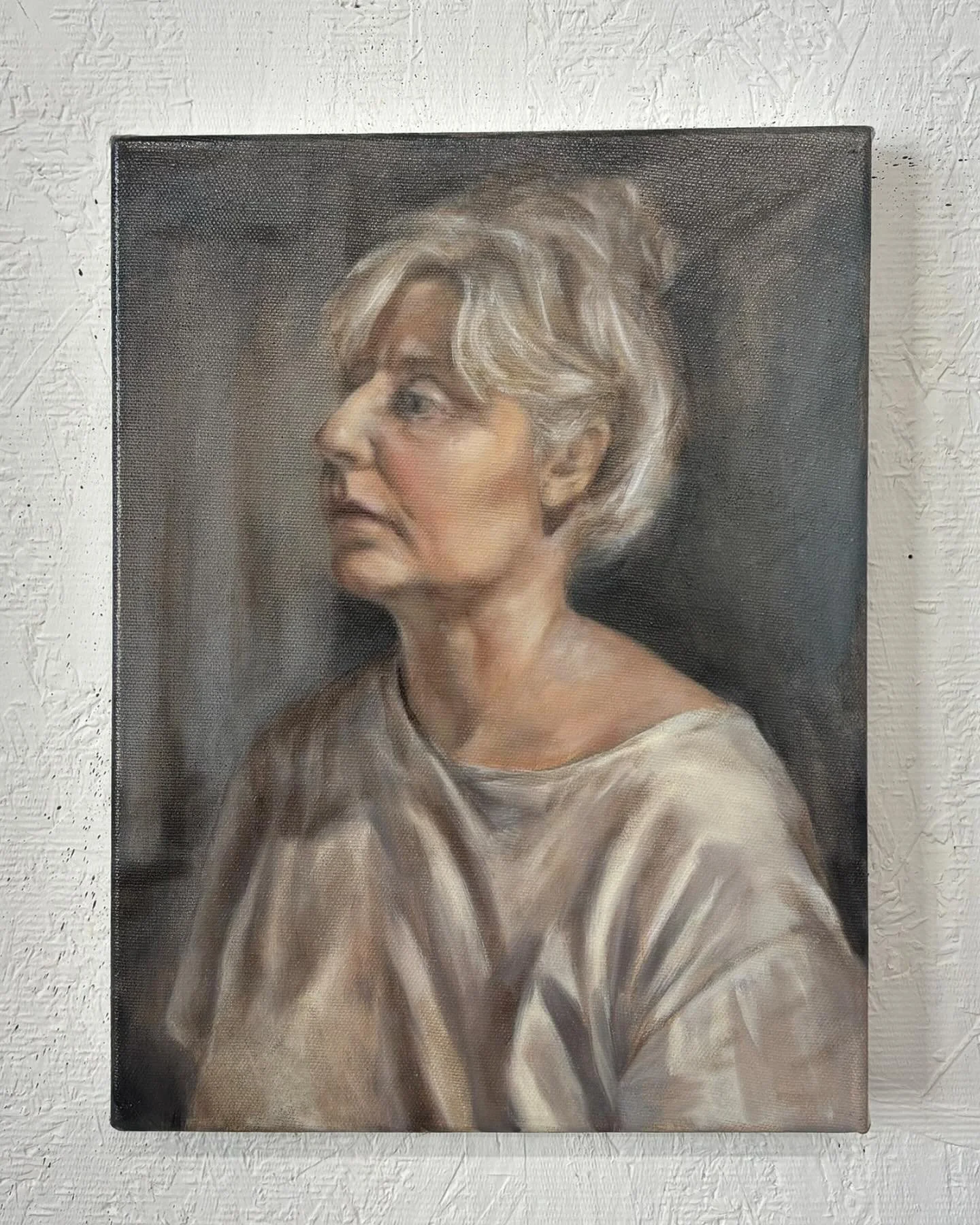Very thankful for my art practice these days. 

Image description:
Image 1: On a white textured wall, a small oil painting is hung. The oil painting is a self portrait of the artist Alice Mackenzie where with help from ai, she has created a represent