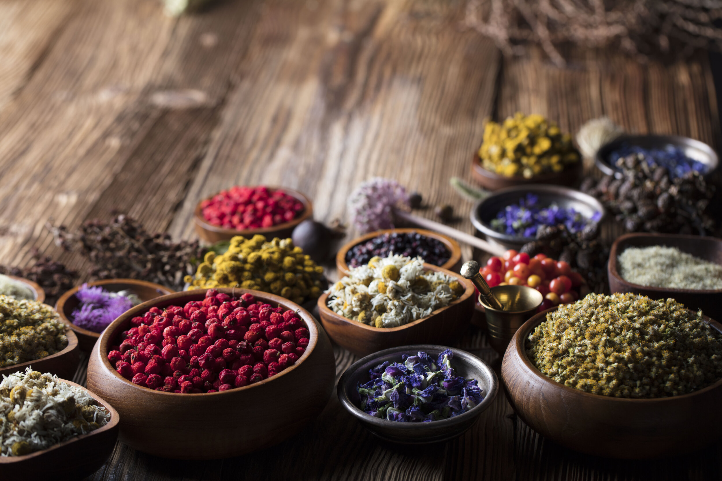 herbs, spices and grains in bowls on wooden table