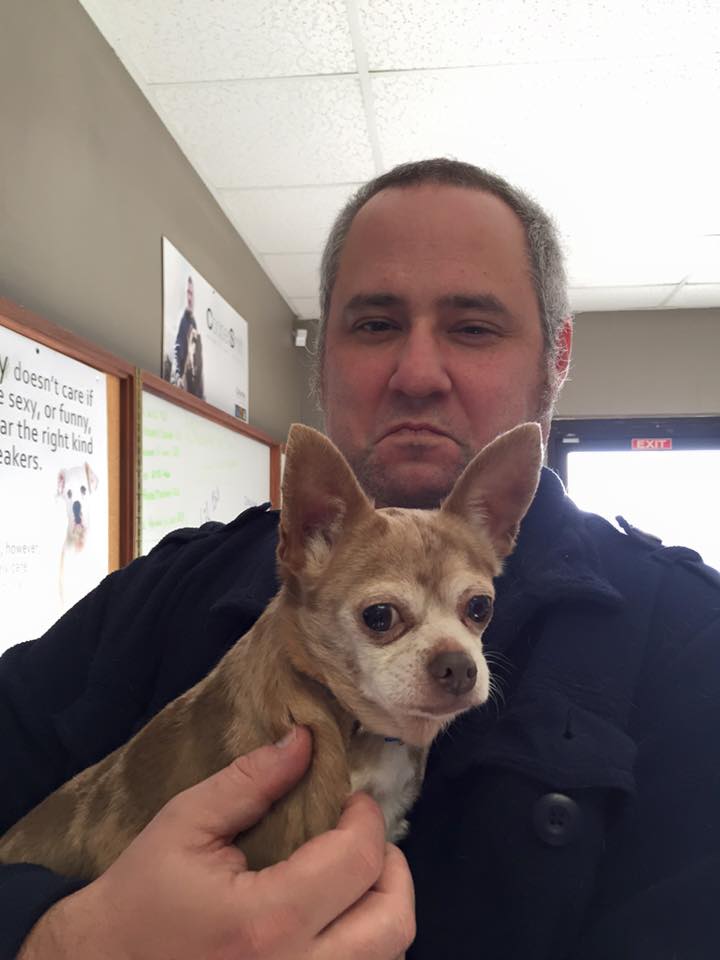 his best "Grumpy Cat" face as snuggling the dog while I fill out paperwork