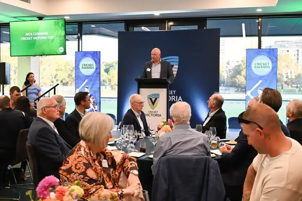 CEO of Cricket Victoria, speaking at a podium during an event with seated attendees.