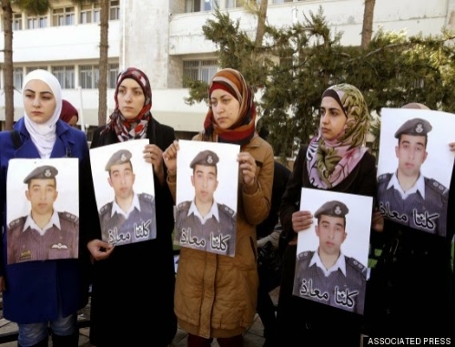 Several Jordanian women with posters of Muath al-Kaseasbeh including his wife Anwar (center)