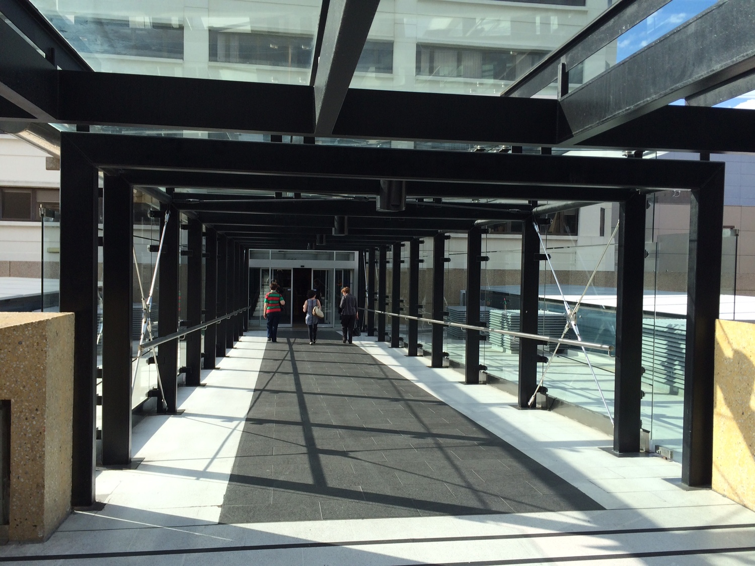 Use Sky Bridge located on Level 1 of Roof Top Car Park. Proceed down Corridor.