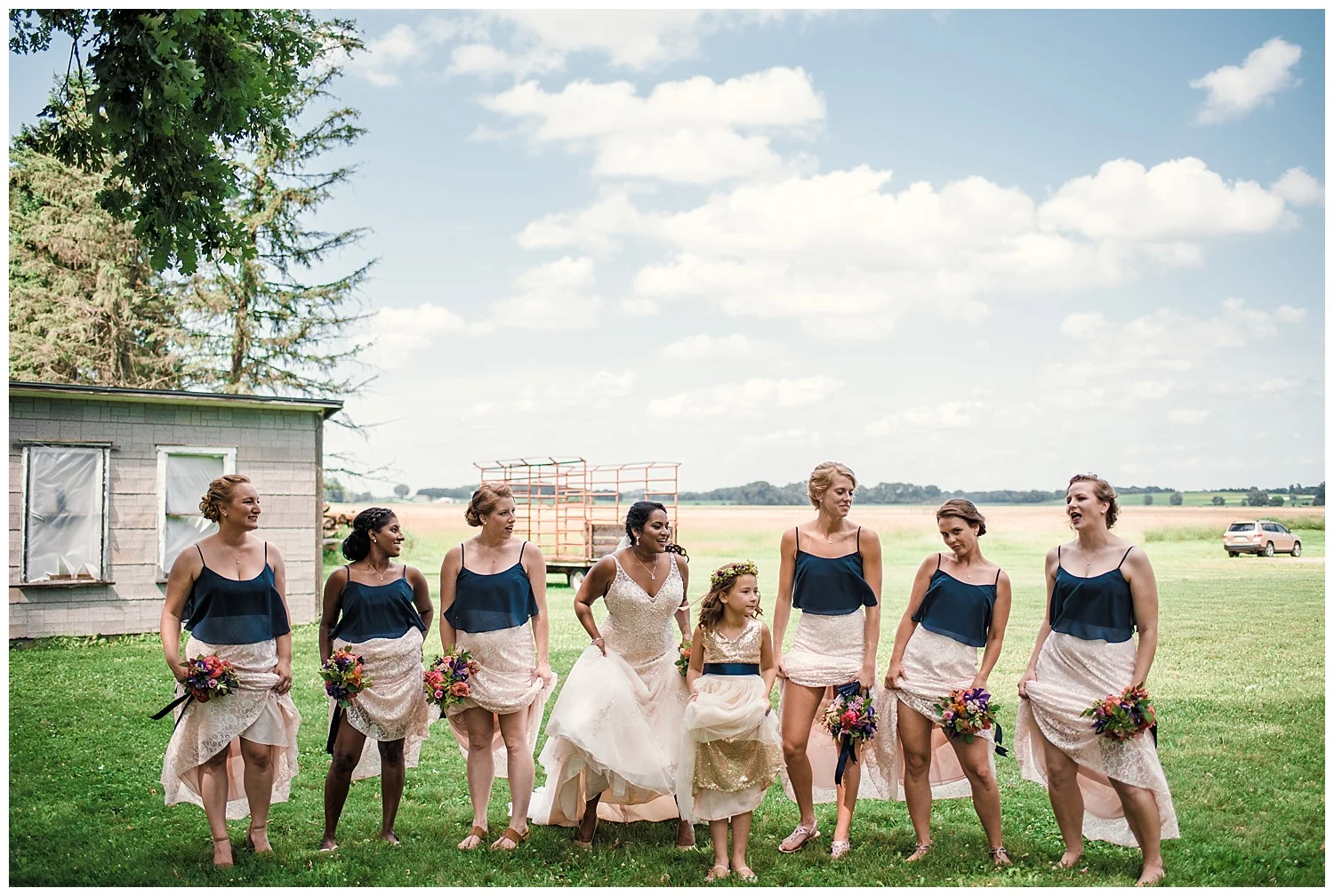 badger farms wisconsin wedding, wisconsin wedding, summer wedding, madison wedding, madison summer wedding, traveling photographer, badger farms, wedding party, bridal party, navy blue bridesmaids dresses, white lace wedding dress, diamond necklace, summer flower bouquet, outdoor wedding, flower girl