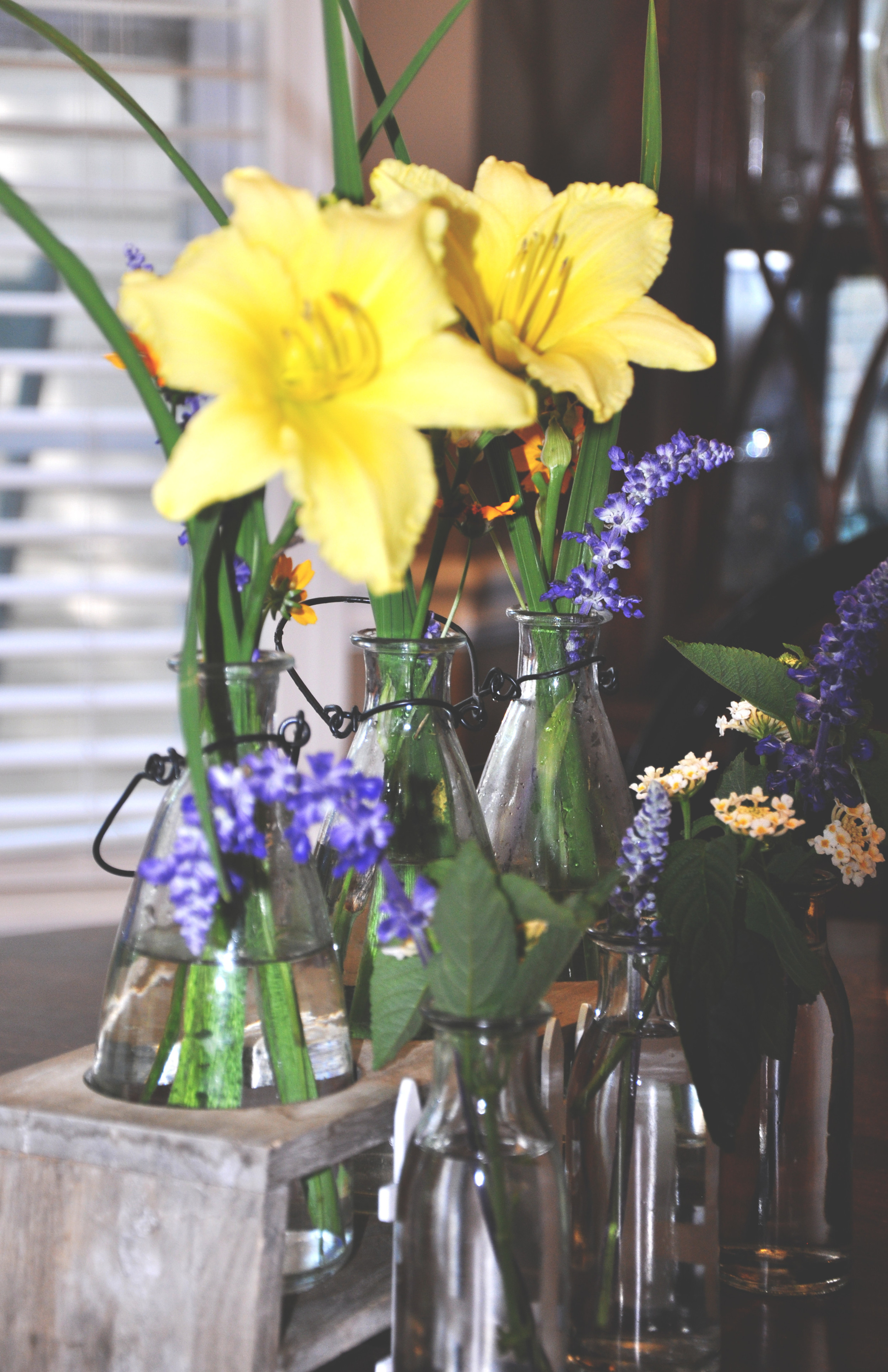 Milk bottles filled with flowers from our yard and arranged by my Mama.