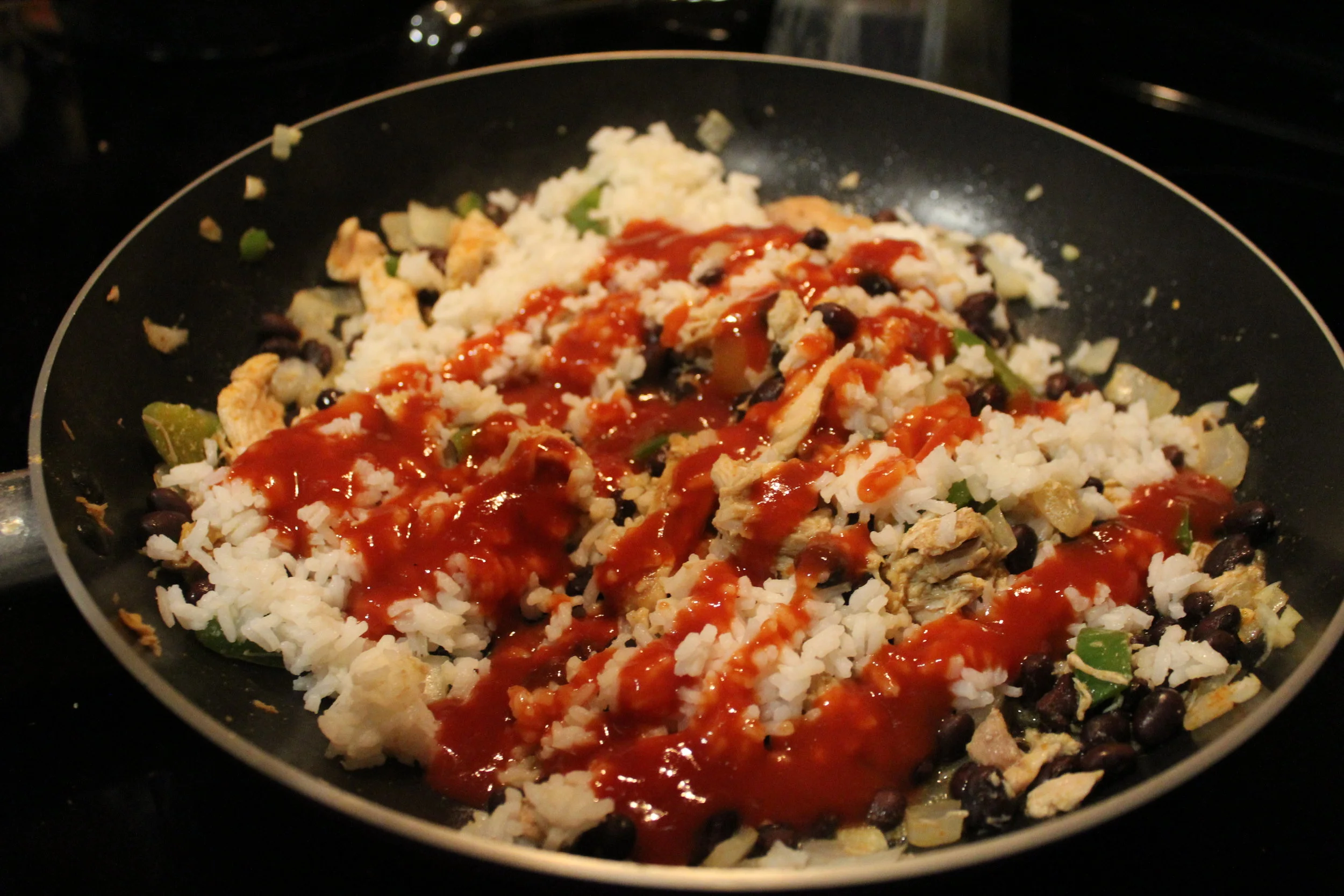 Add in the rice, beans, & sauce. I usually let this cover and simmer until the rice is cooked (of course I use the 5 minute quick rice), this lets the flavors blend together. Ethan loves him some taco sauce - there's never enough. 
