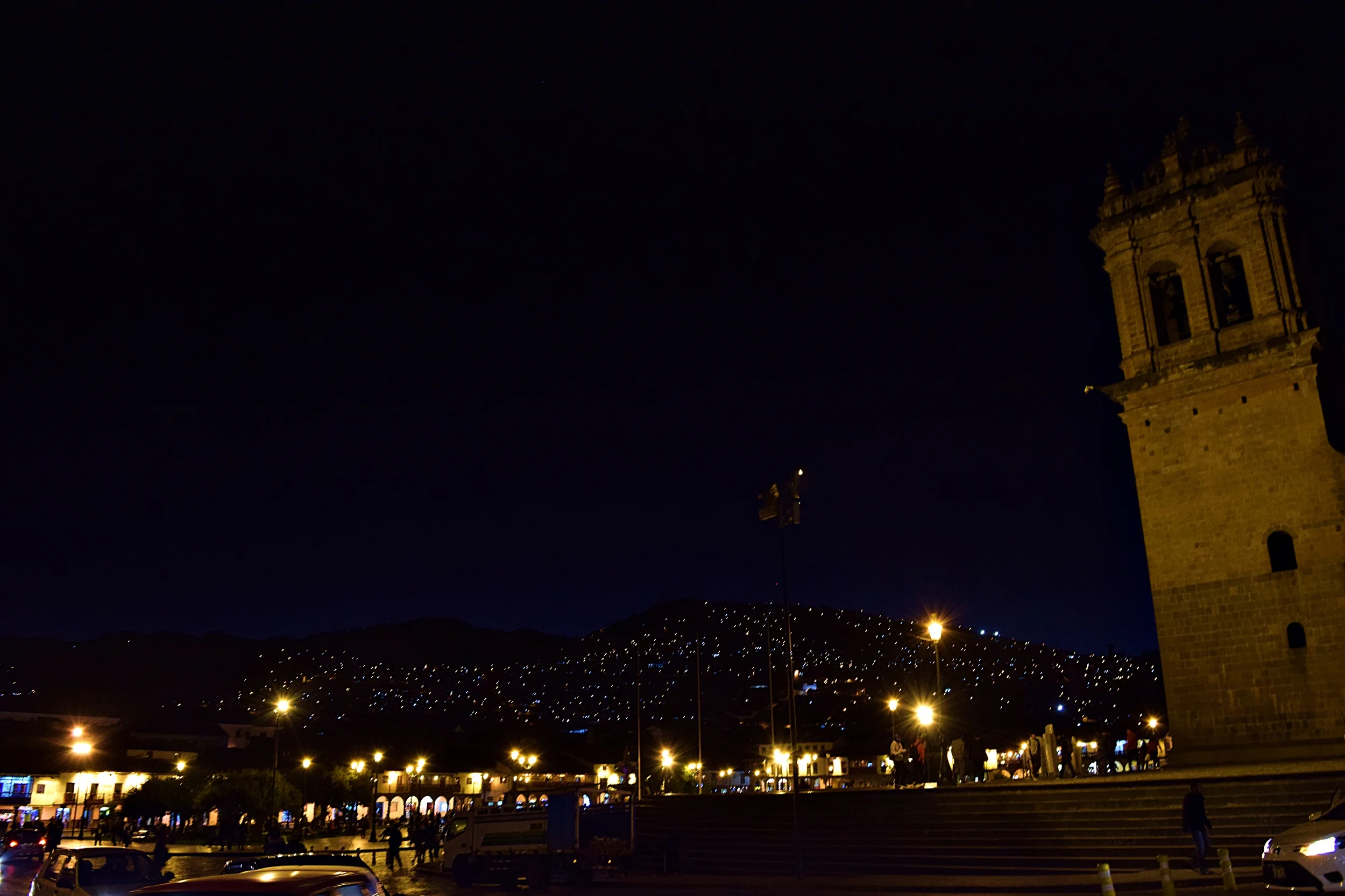 The hills of Cusco lit up at night from the Plaza de Armas.