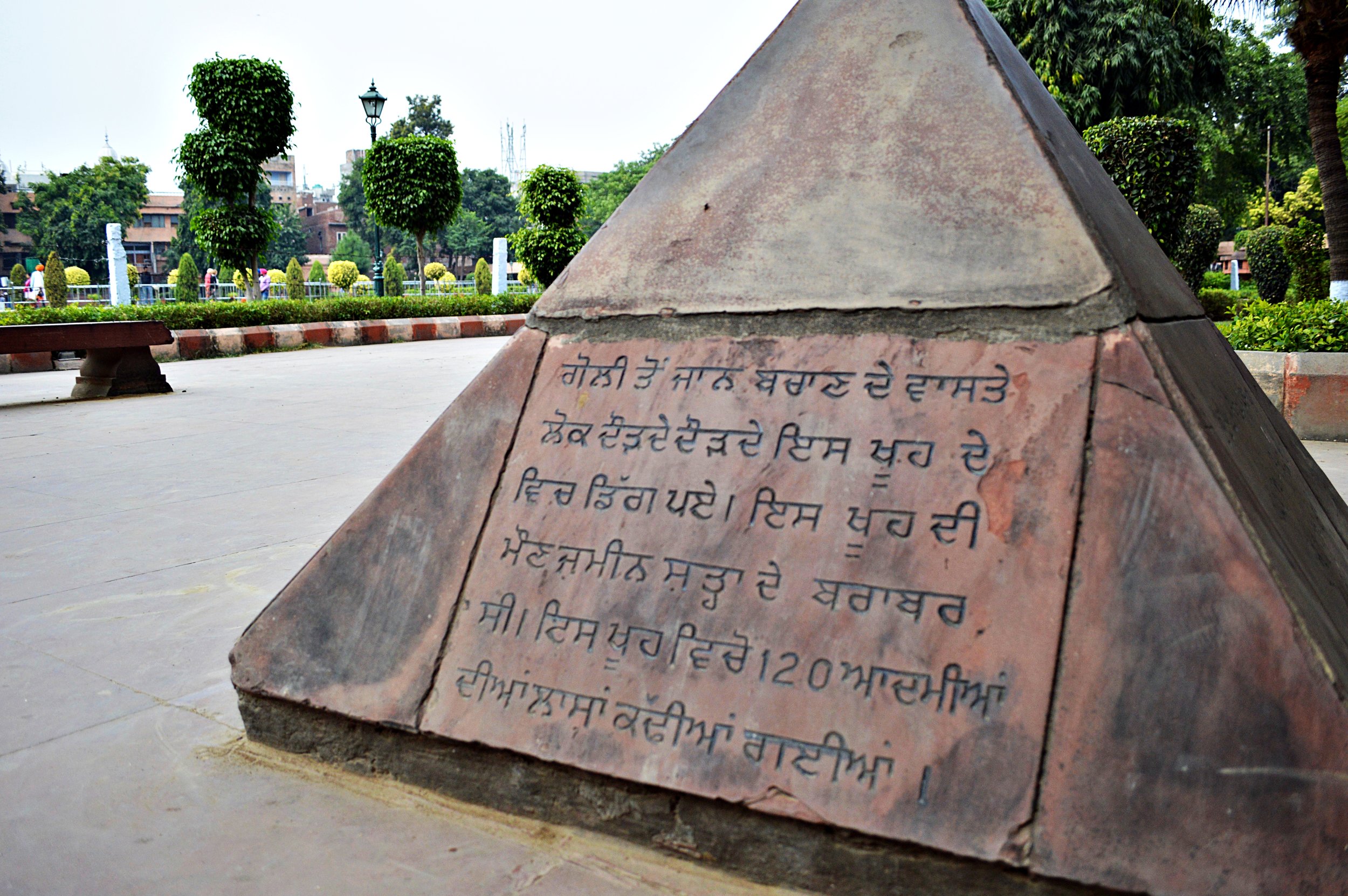 Sign at Jallianwala Bagh describing how at least 120 people jumped to their death in a well instead of being shot during an unprecedented attack by the ruling British. Amritsar, Punjab.