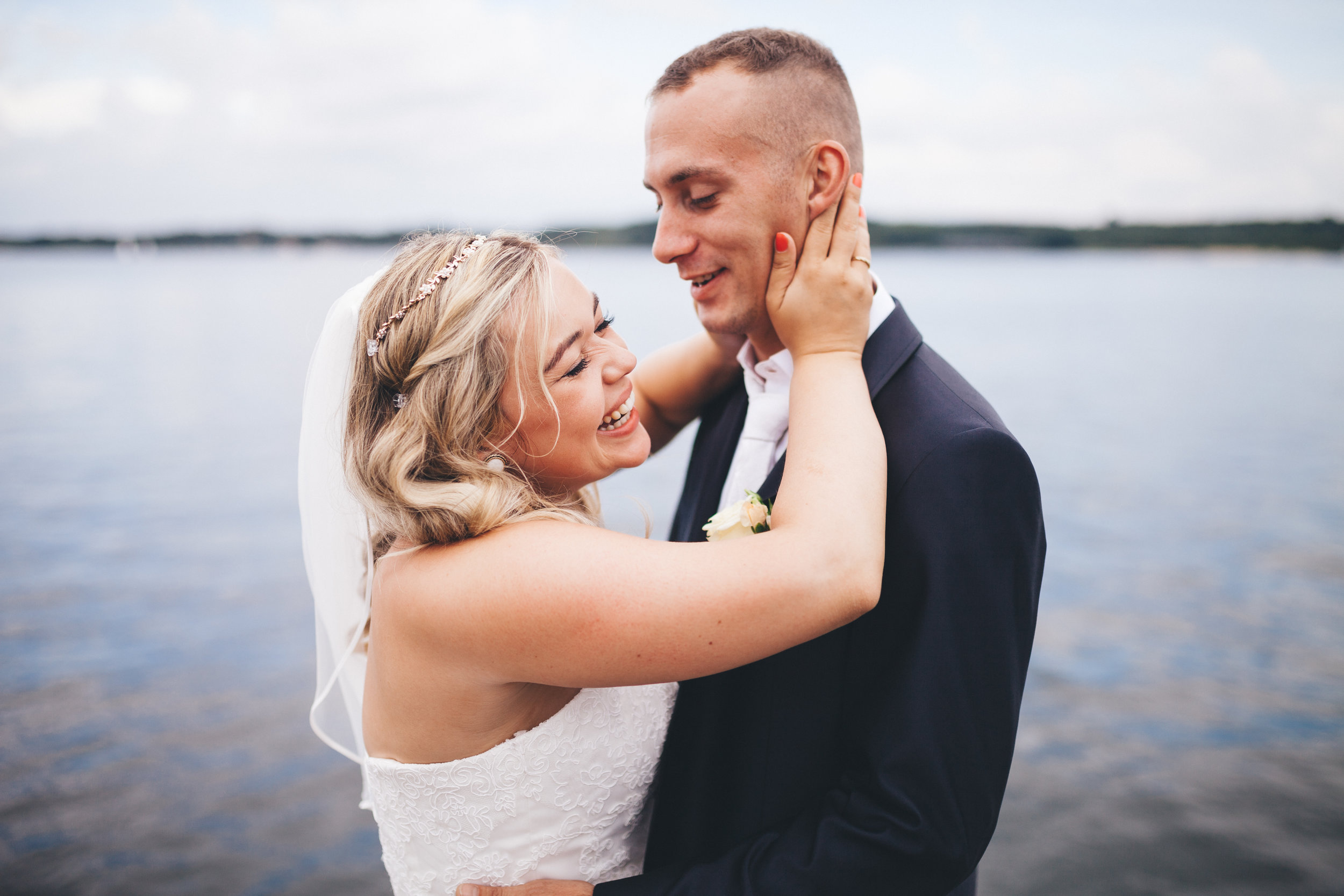 Eine Frau hält ihren mann hinterm kopf fest und lacht dabei. Sie sind verliebt und frisch verheiratet. Fotografiert bei einem Fotoshooting in Kiel von Phil Schreyer