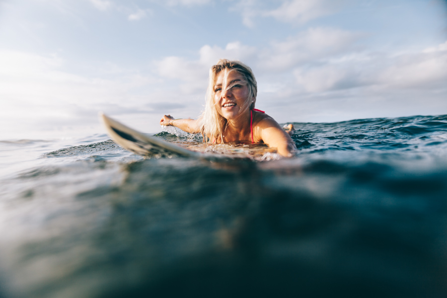 Josi paddelt auf ihrem Surfboard der Sonne entgegen