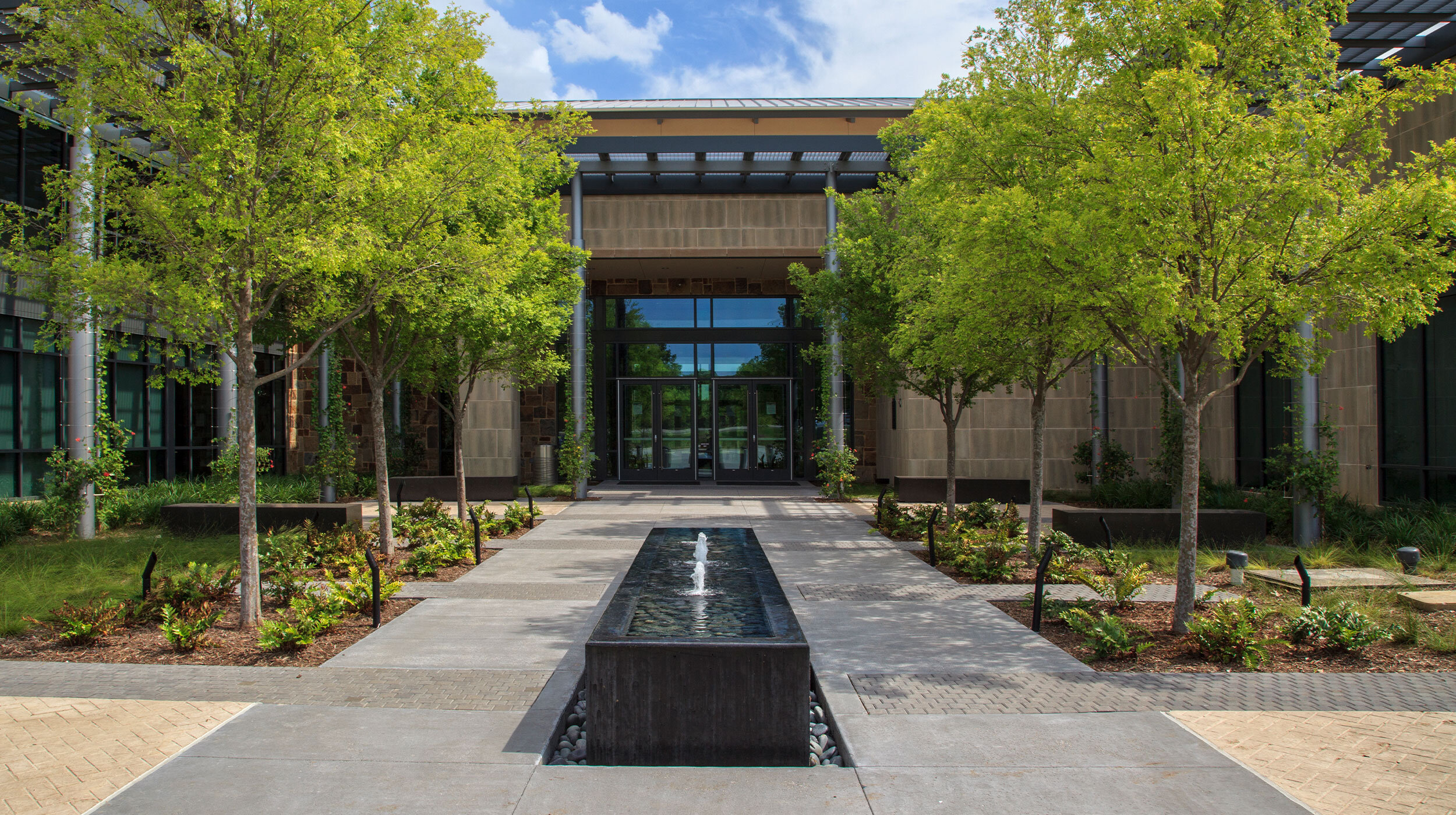 Flower Mound Town Hall Flower Mound, Texas Flower Mound Town Hall is an inspiring civic project that celebrates natural systems as well as functional civic space. As the town of Flower Mound grows in population and envisions their future, a focus on environmental sustainability became a key effort. Native plantings, a monarch waystation, bioswales, and a large retention pond make the site inviting and ecologically responsible. An axis of paving material leads staff and visitors into a shaded courtyard, or around the building to the more naturalized part of the site that connects to the local trail system. Client: Town of Flower Mound Photographer: Arlen Kennedy Photography