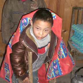 Young boy cuddled up with quilt