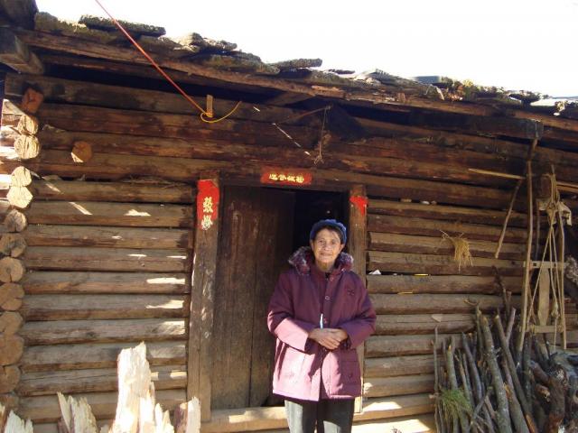 Lisu women outside her home wearing new winter coat