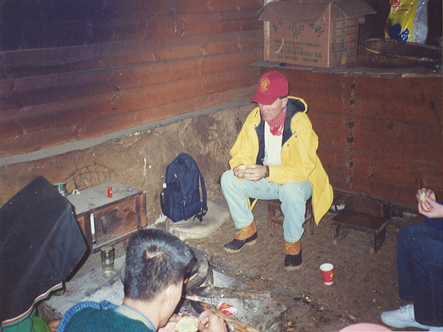 Brad eating a fire baked potato in Yi village home